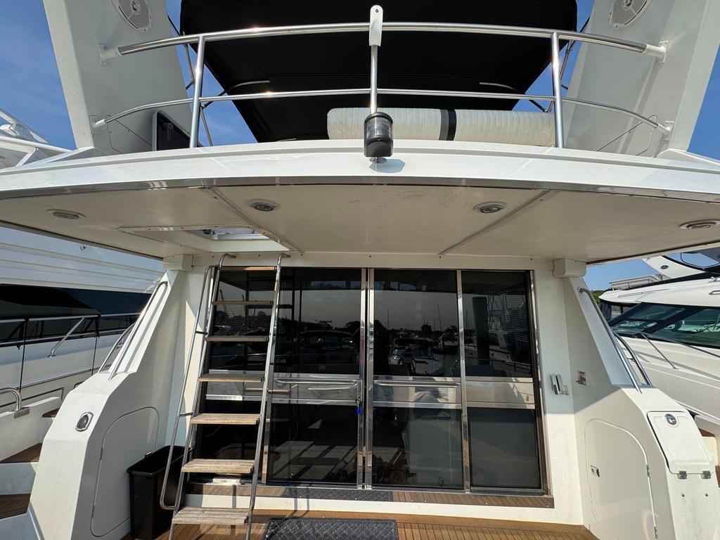 1989 Birchwood 62 Cockpit Motor Yacht with sliding glass doors and upper deck railing.