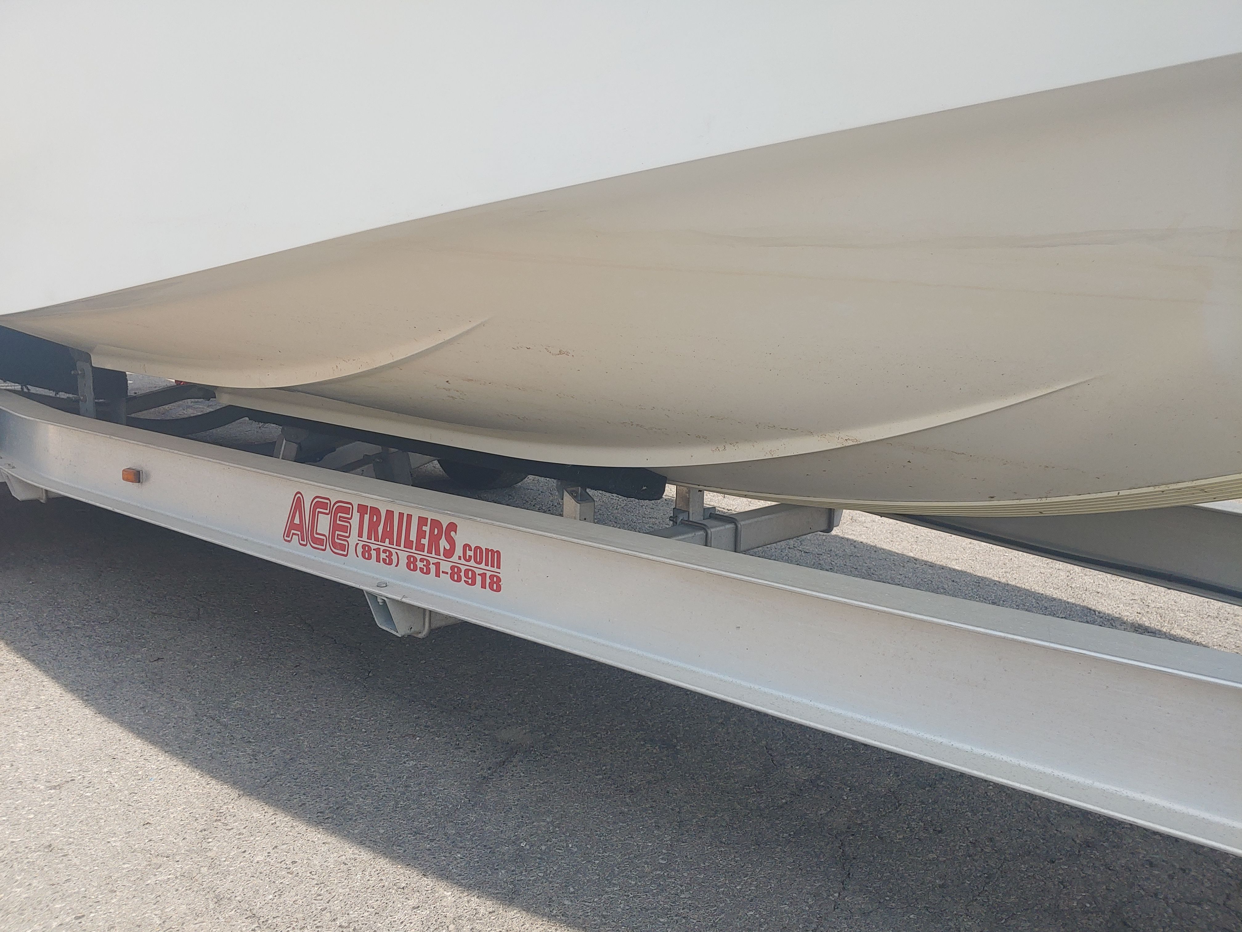 A boat on a trailer, partially visible, with "ACE TRAILERS" written on it.