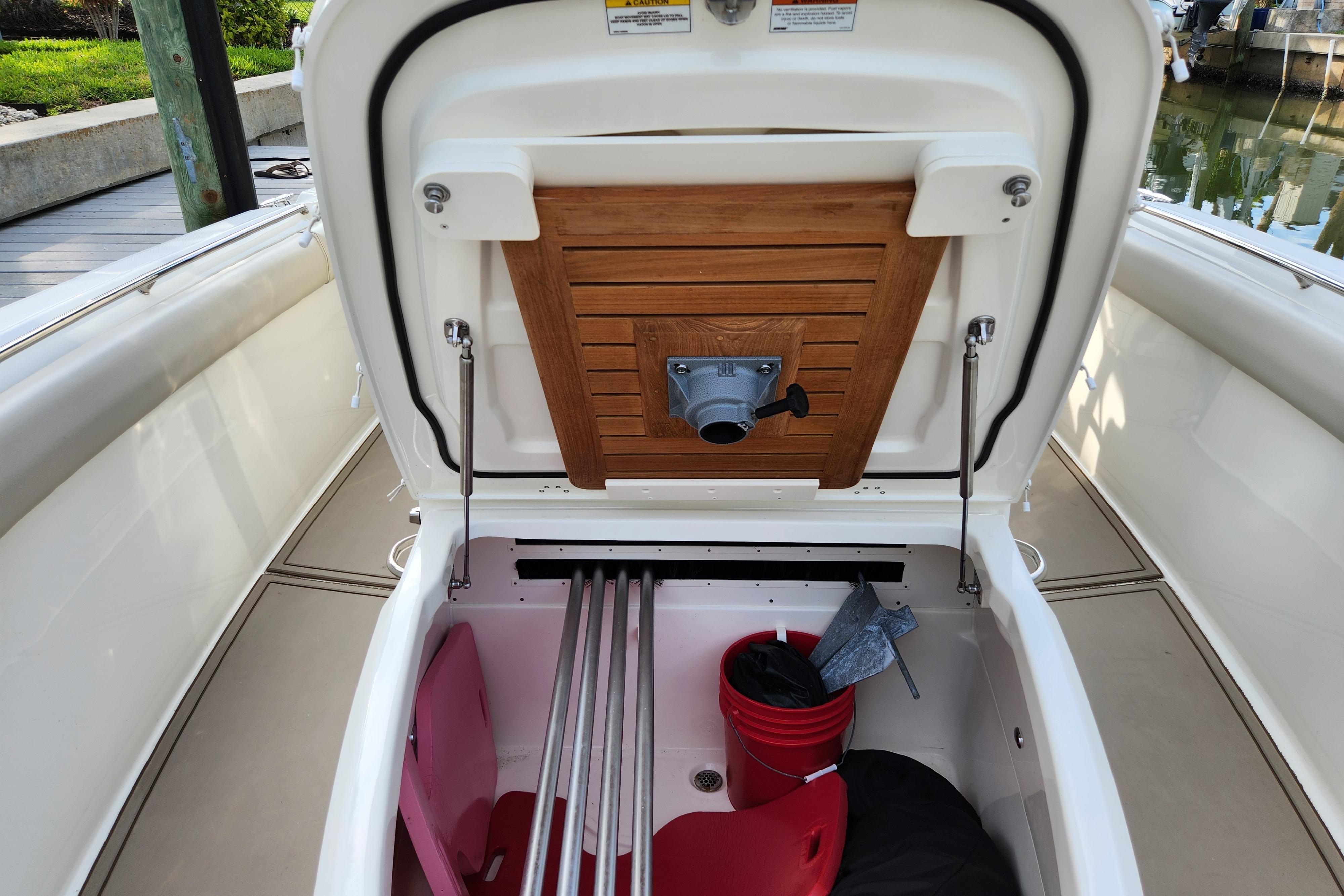 2022 Boston Whaler 330 Outrage storage compartment with open hatch, showcasing interior space.