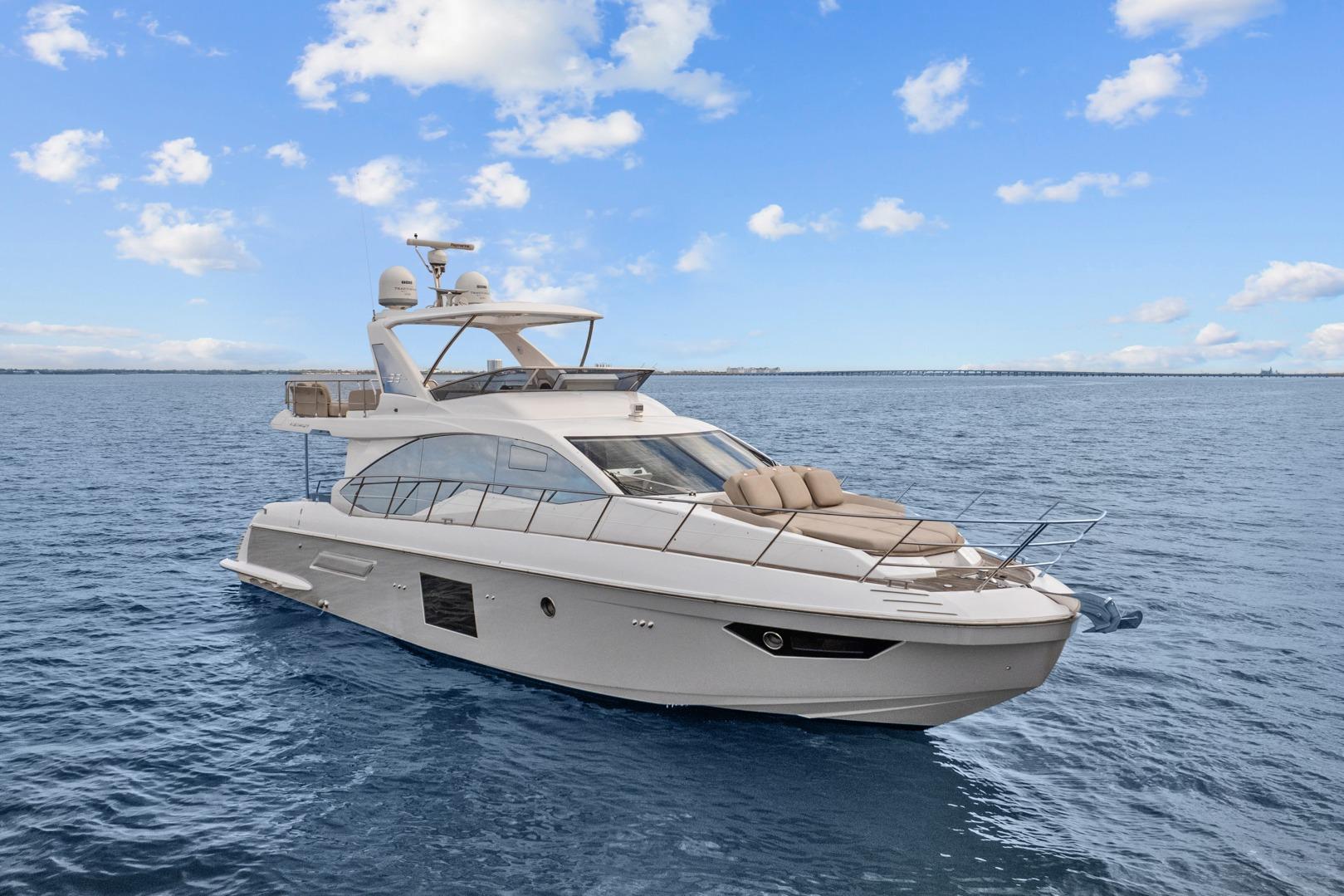 Luxurious 2019 Azimut 55 yacht cruising on open water under a clear blue sky.