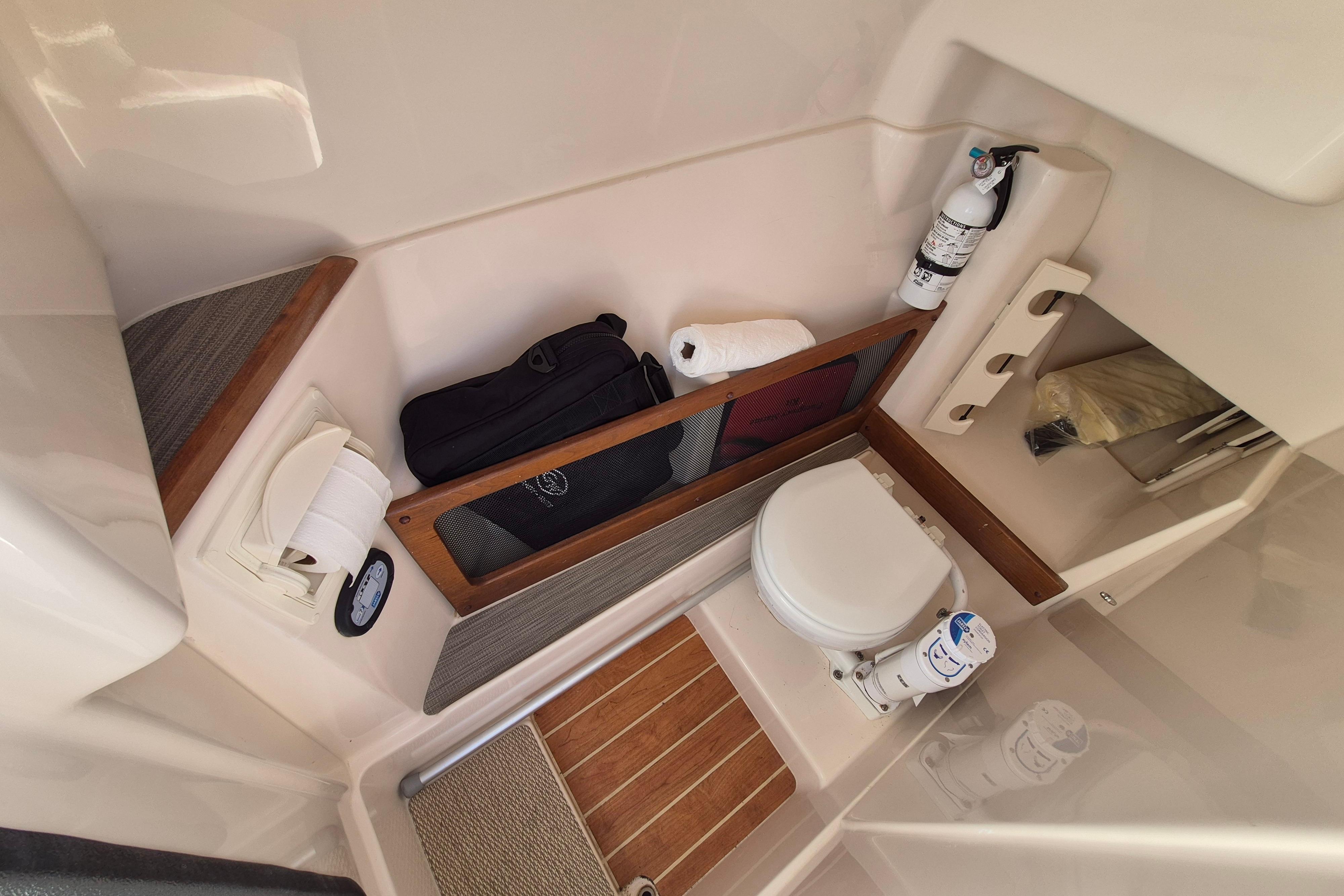 Interior of 2025 Grady-White Freedom 275 boat, featuring compact bathroom amenities.