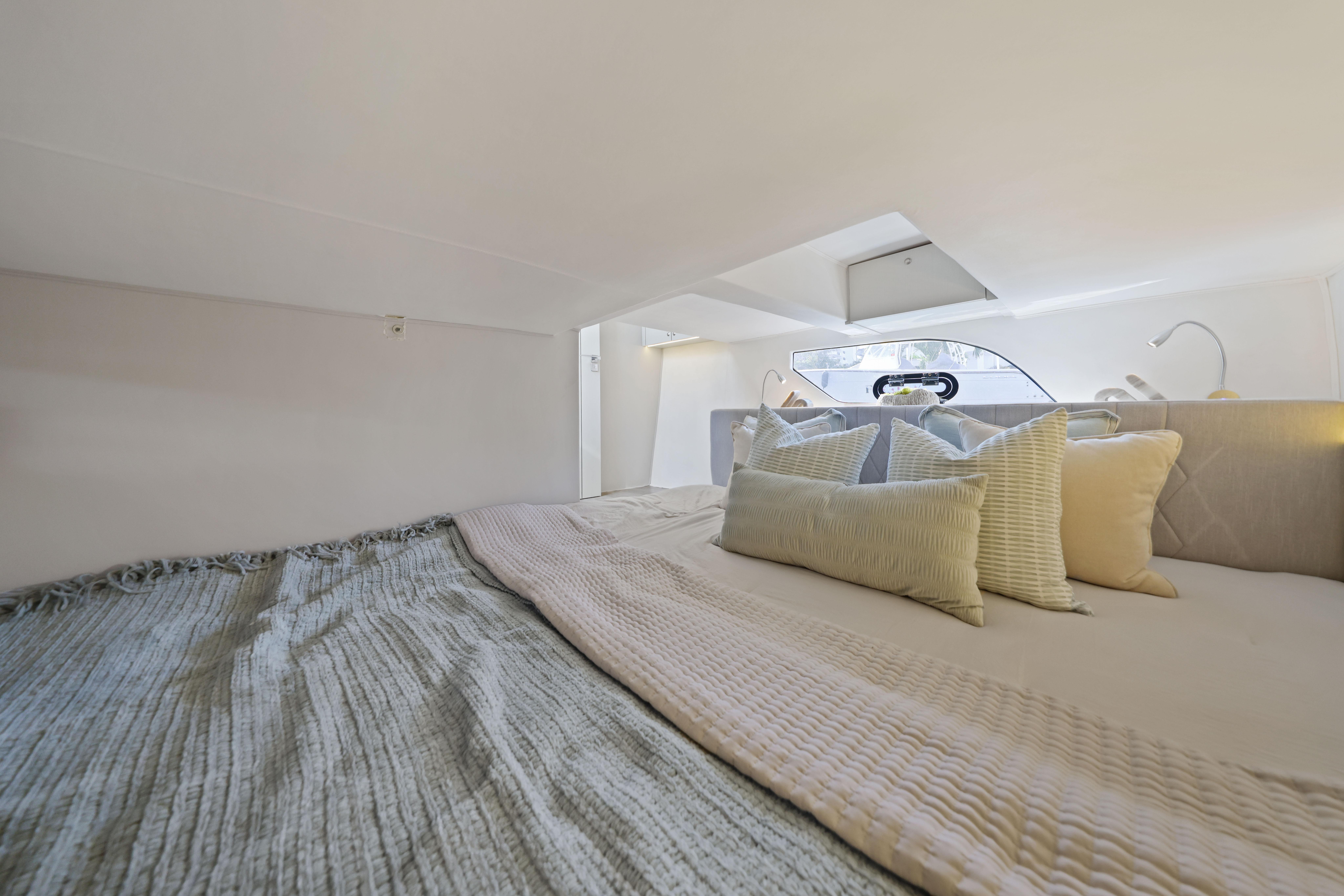 Luxurious cabin interior of 2025 Valiatt 380 Bowrider with cozy bedding and pillows.