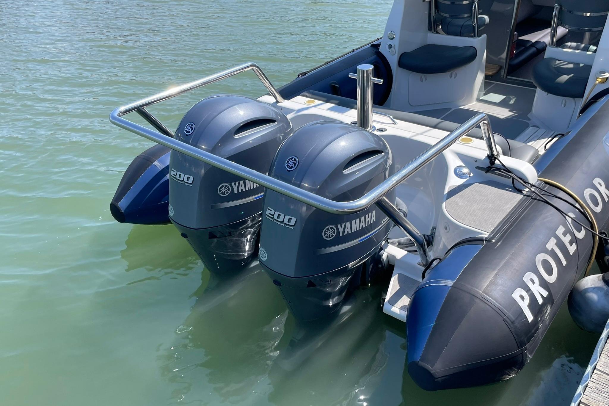 2006 Protector Targa 28 boat with dual Yamaha 200 engines on calm water.