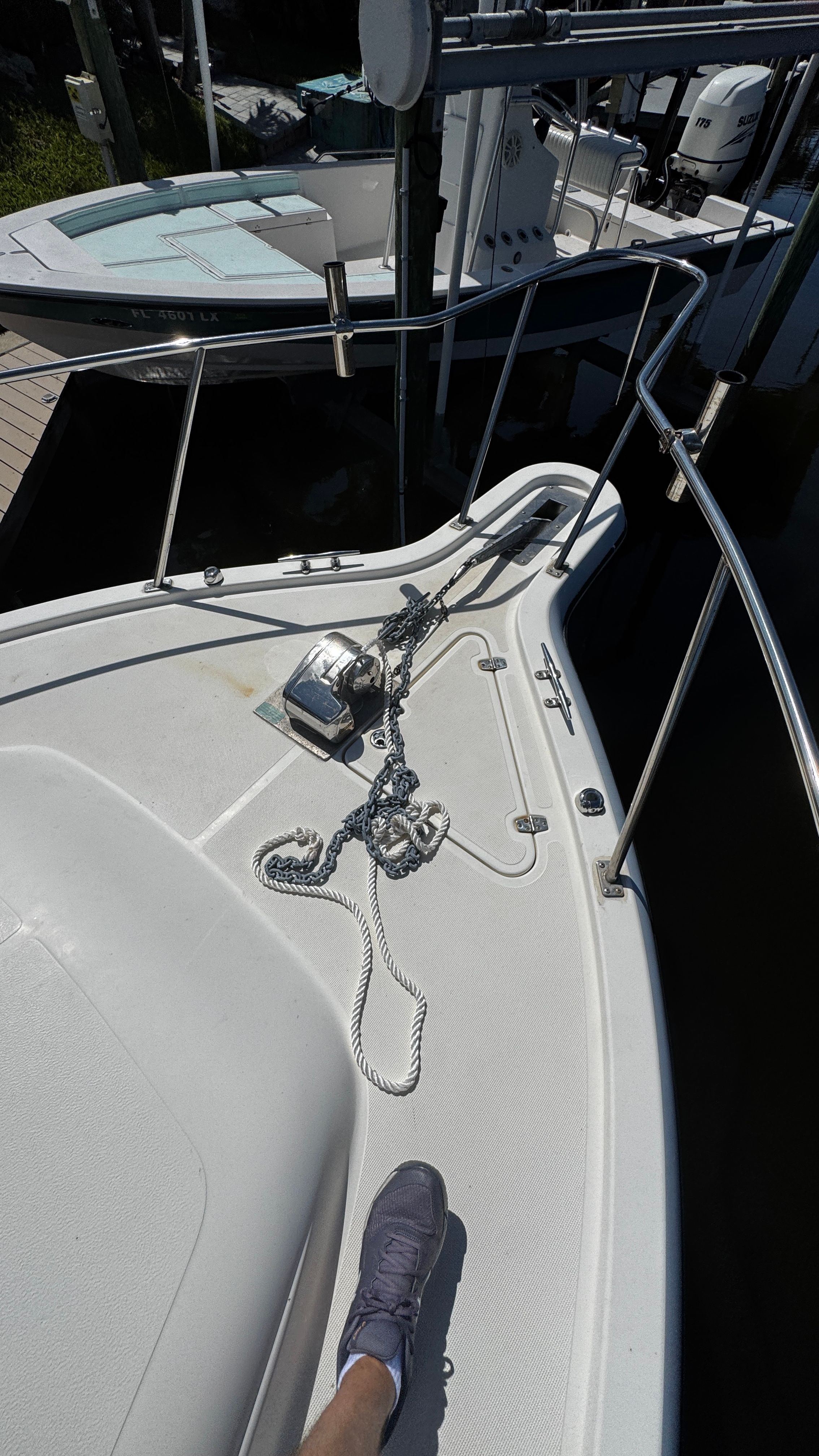 Foredeck of a 2003 Pursuit 3070 with anchor and chain, next to another boat.