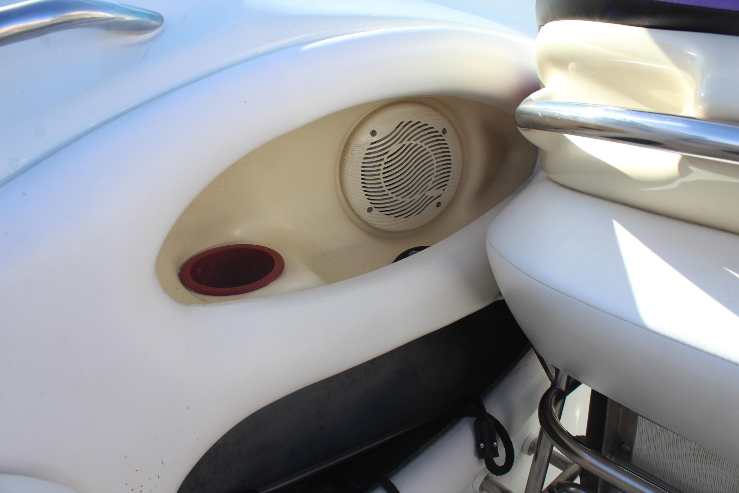Interior of a 1996 Baja 232 boat featuring a speaker and cup holder.