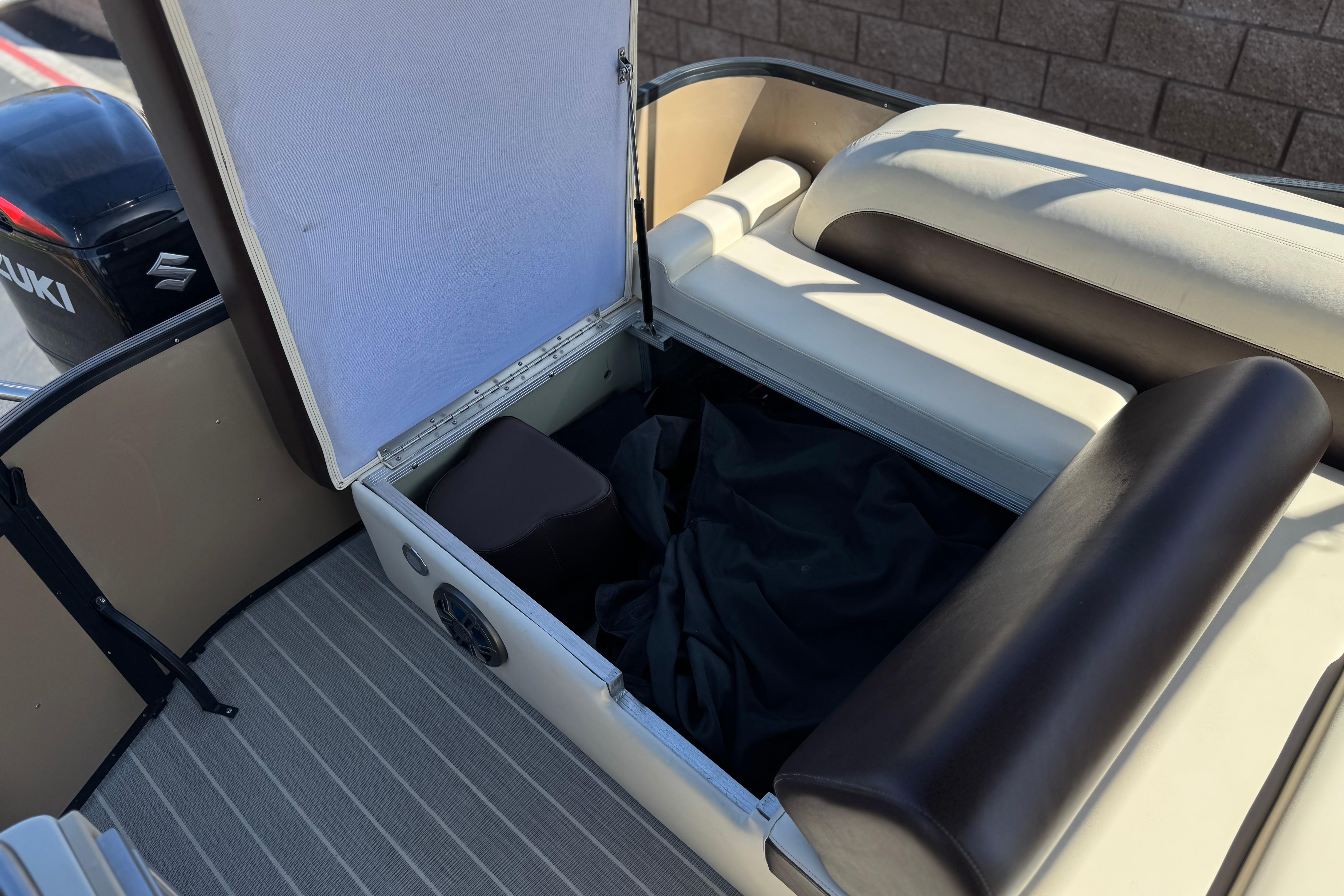 2023 Lexington 623 ST Xtreme boat storage compartment with open seat and Suzuki engine.