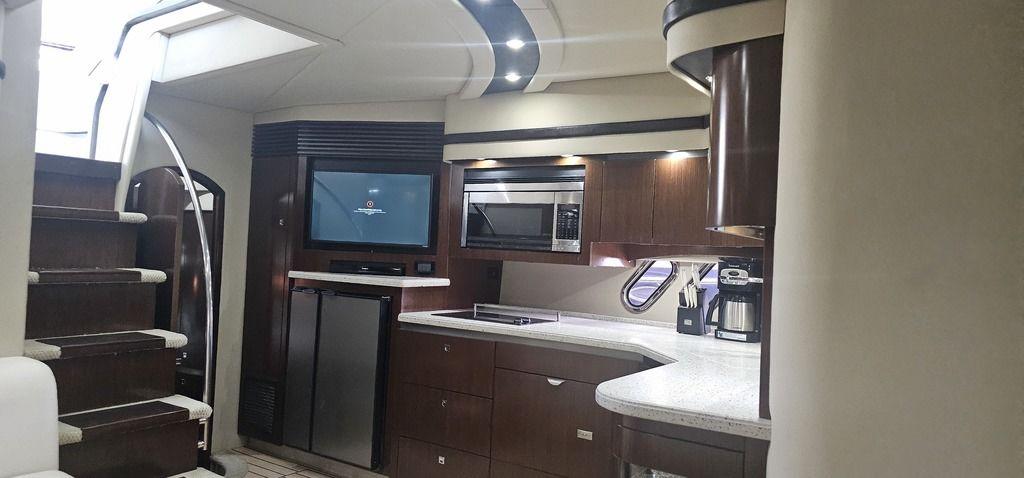 Luxurious interior of 2011 Cruisers Yachts 540, featuring modern kitchen and entertainment area.