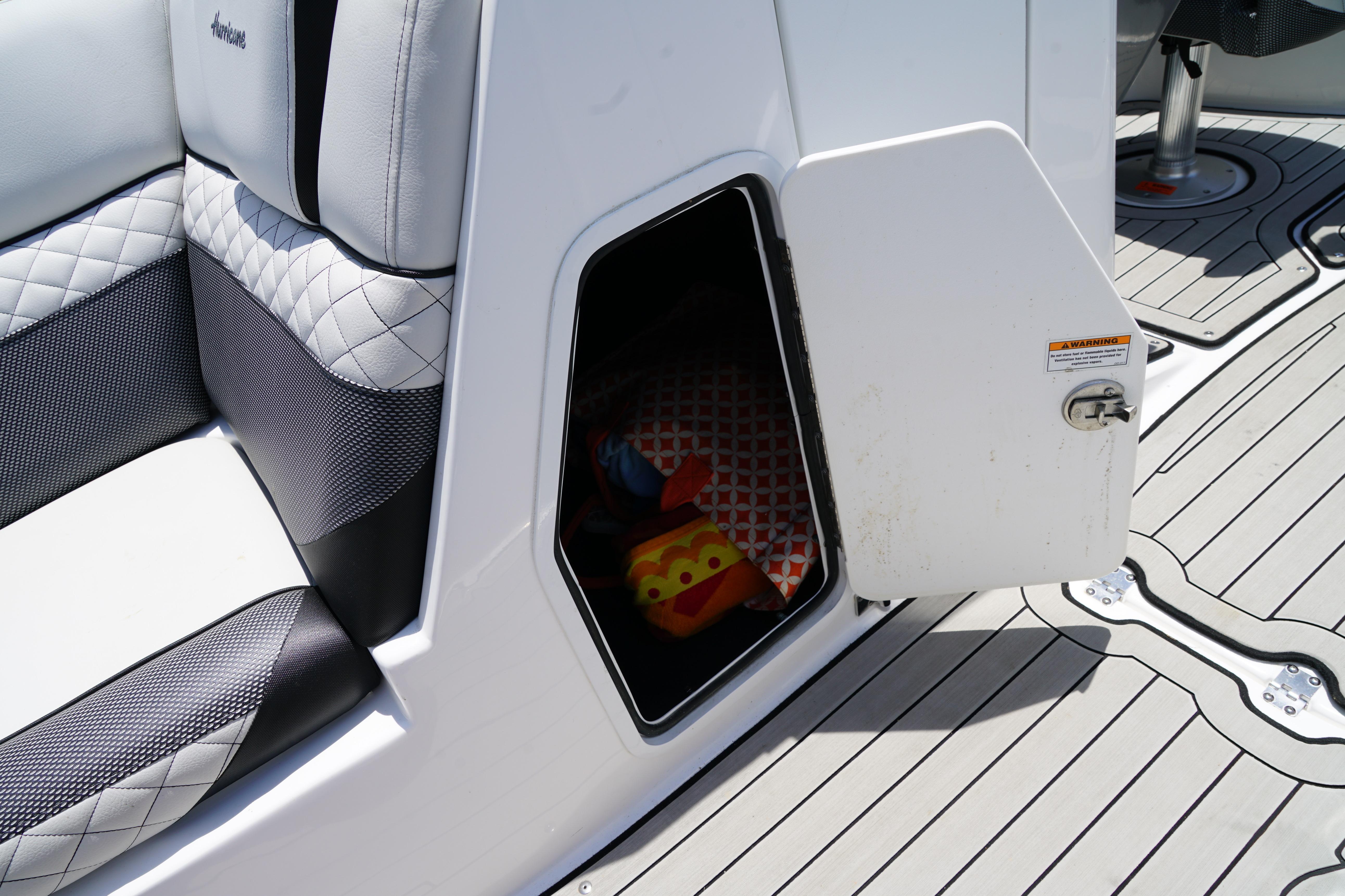 Storage compartment on 2020 Hurricane SunDeck 2486 OB boat with open door and visible contents.