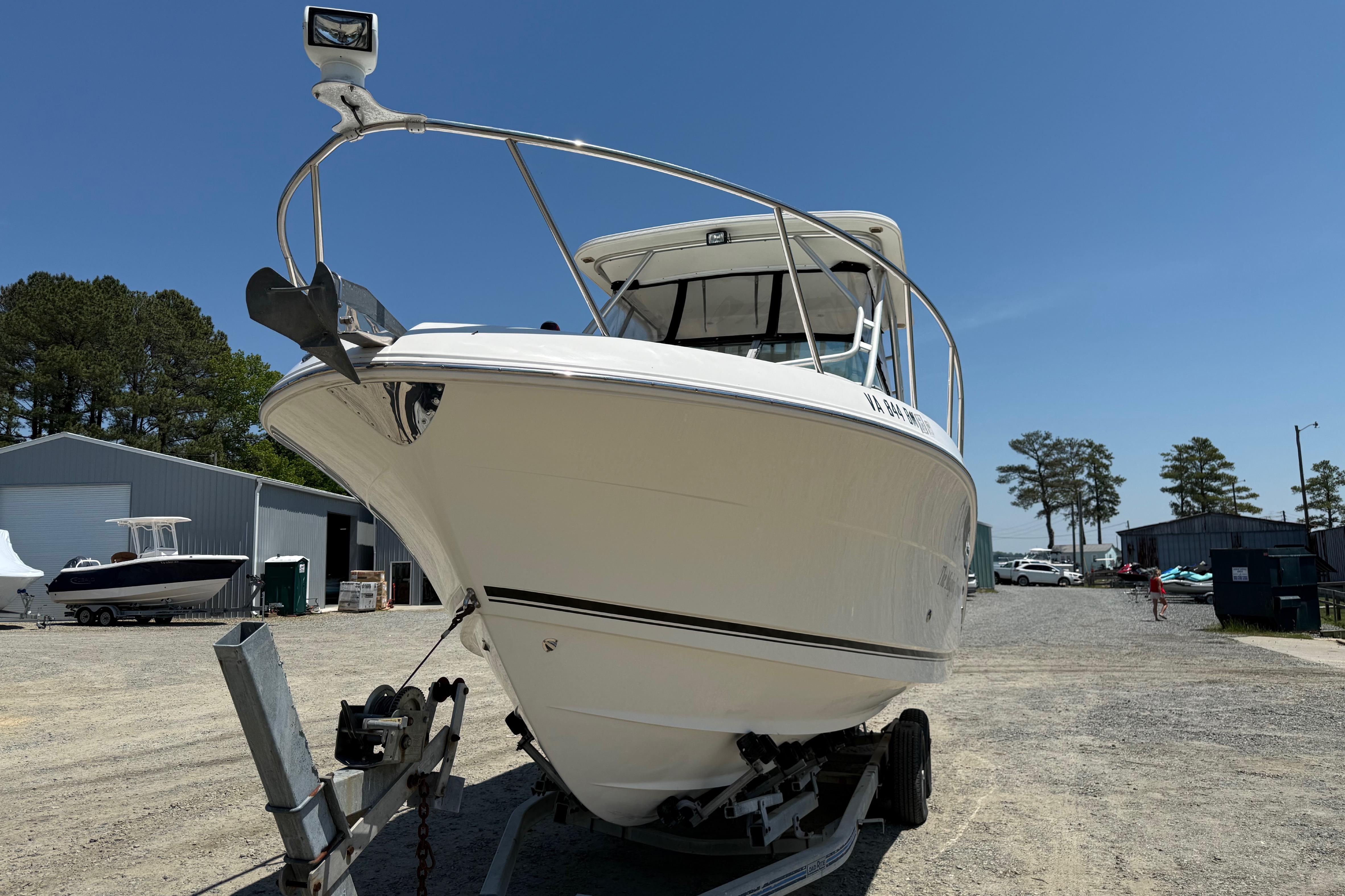 2007 Robalo R305 Walkaround boat on trailer in outdoor storage area.