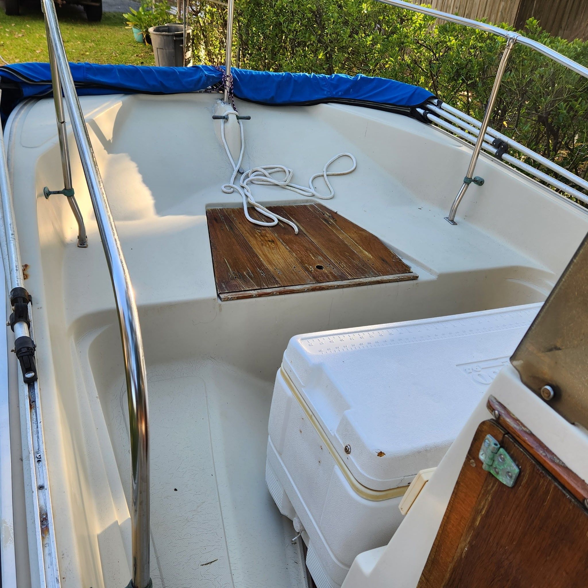 A 1976 Boston Whaler MONTAUK with a white deck, blue cover, and wooden elements.