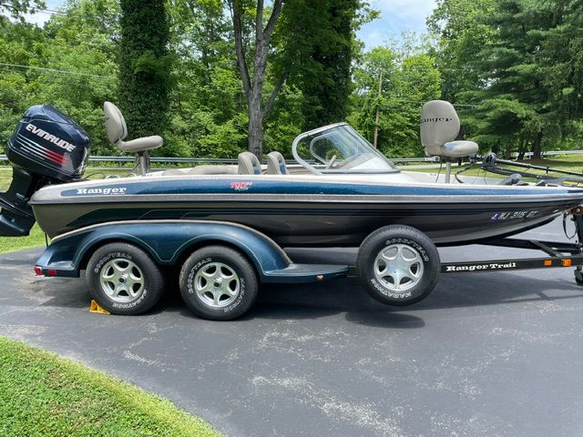 2004 Ranger 190 Reata on a trailer, with Evinrude motor, parked in a green setting.