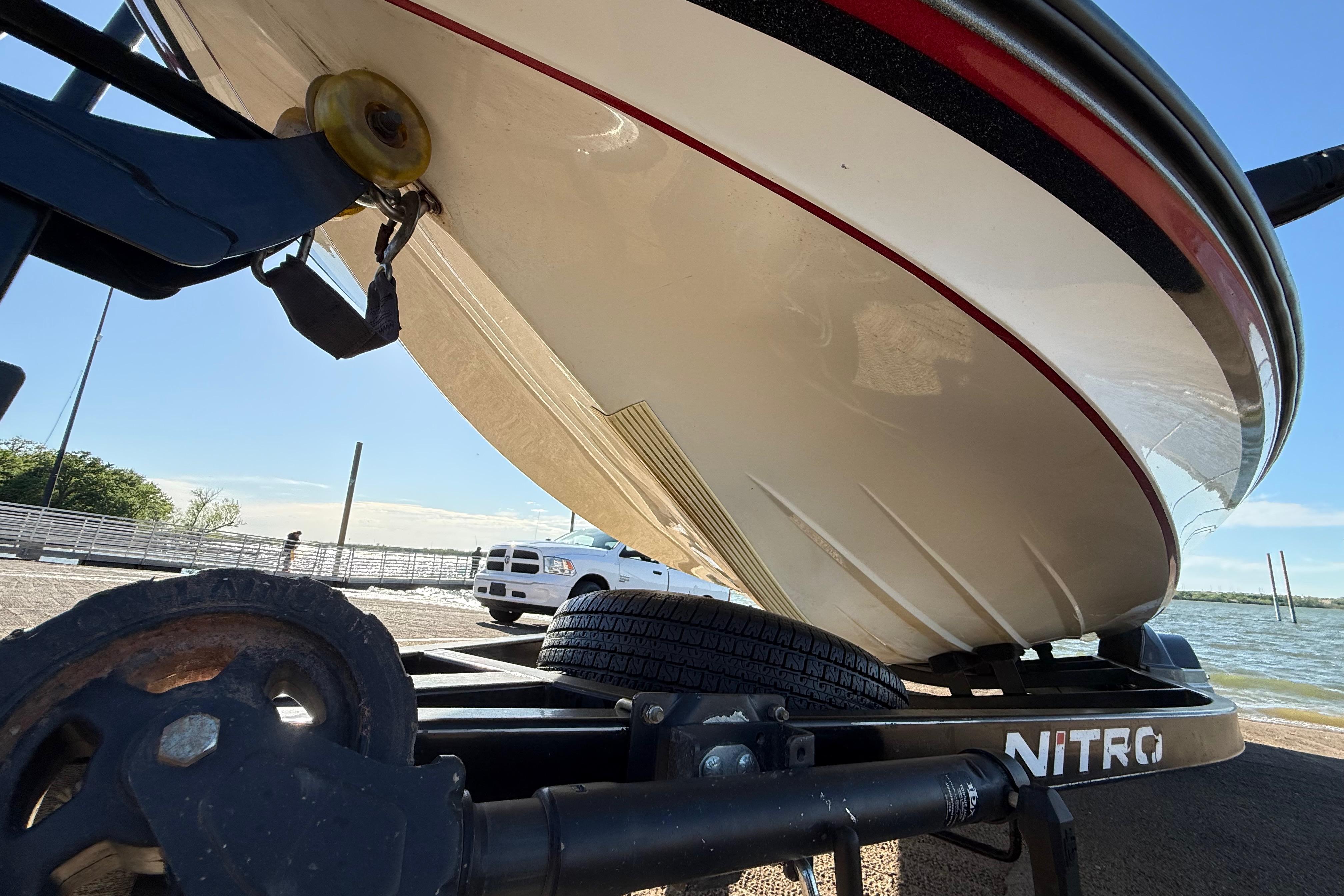 2016 Nitro Z21 boat on trailer near a lake, showcasing hull design.