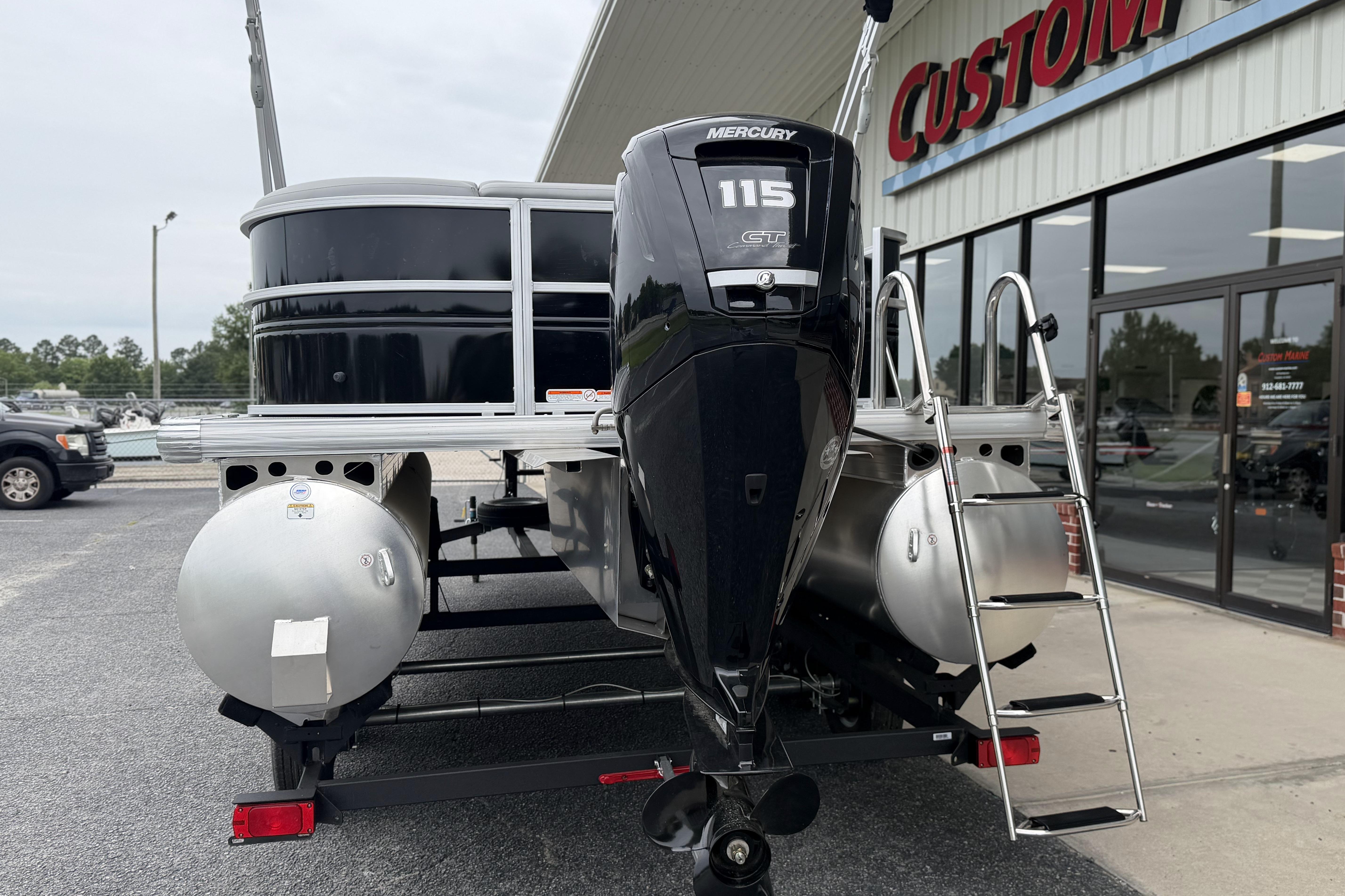 2026 Sun Tracker Party Barge 20 DLX with Mercury 115 GT engine, parked outside dealership.