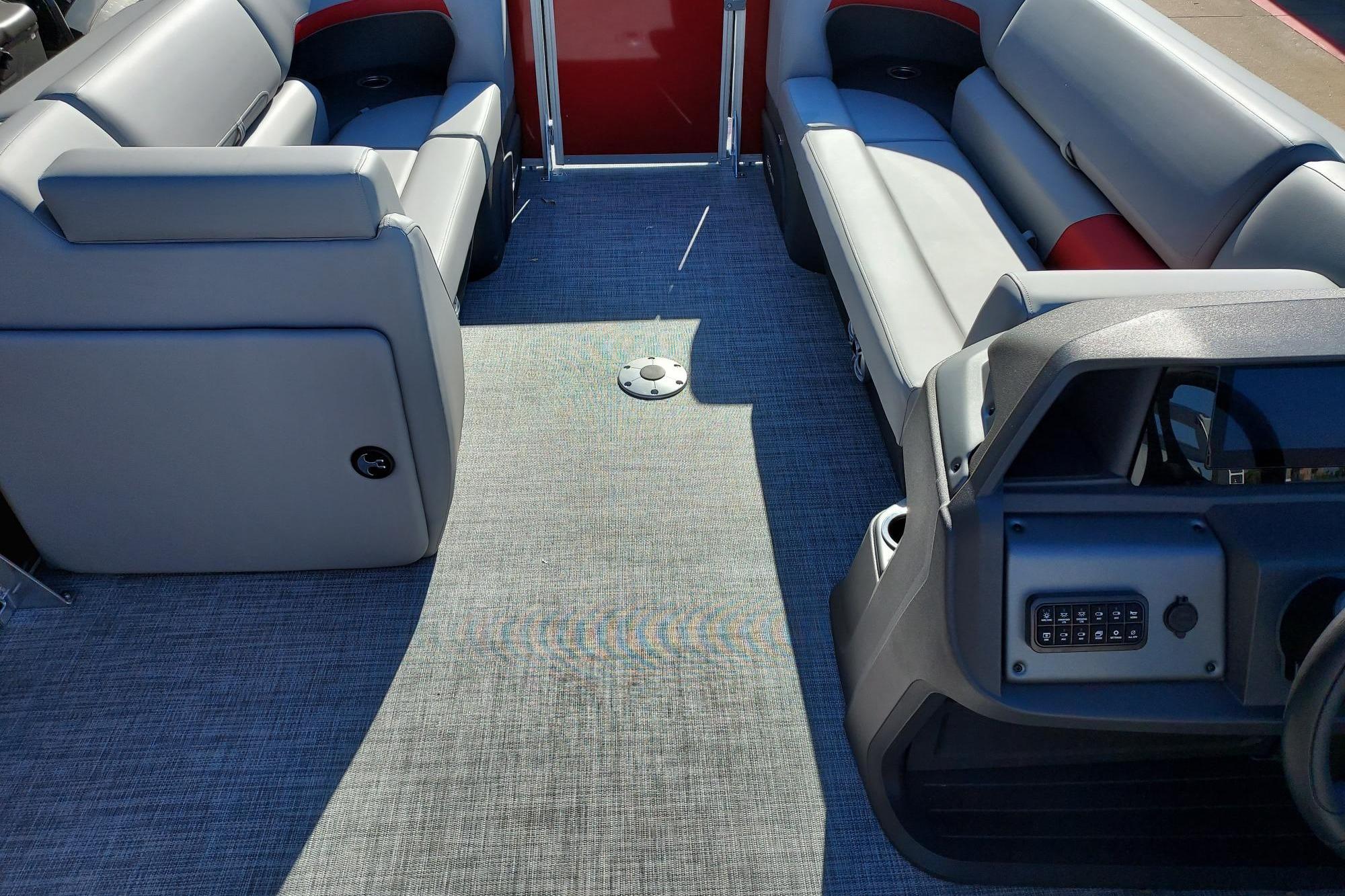 2026 Sun Tracker Party Barge 22 DLX interior with gray seating and modern dashboard.