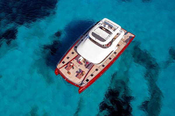 Aerial view of 2025 Lagoon SIXTY 7 yacht on clear blue water.