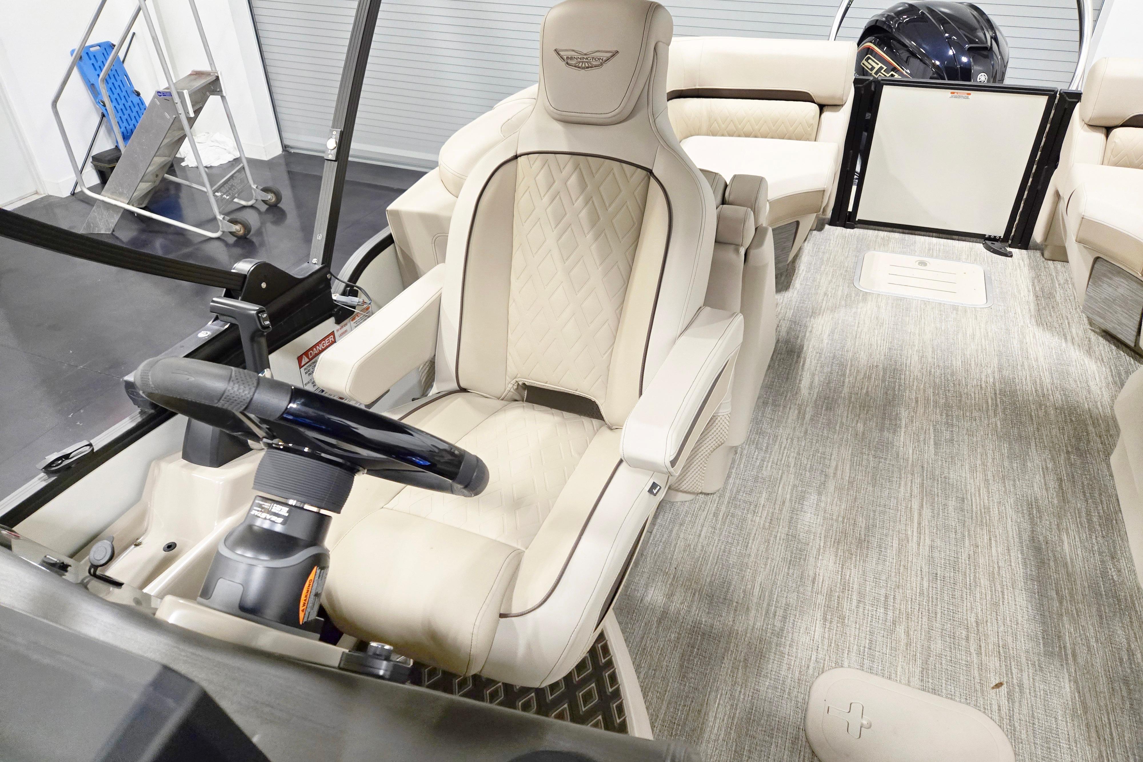 Luxurious interior of 2026 Bennington 24 M boat with plush seating and modern steering.