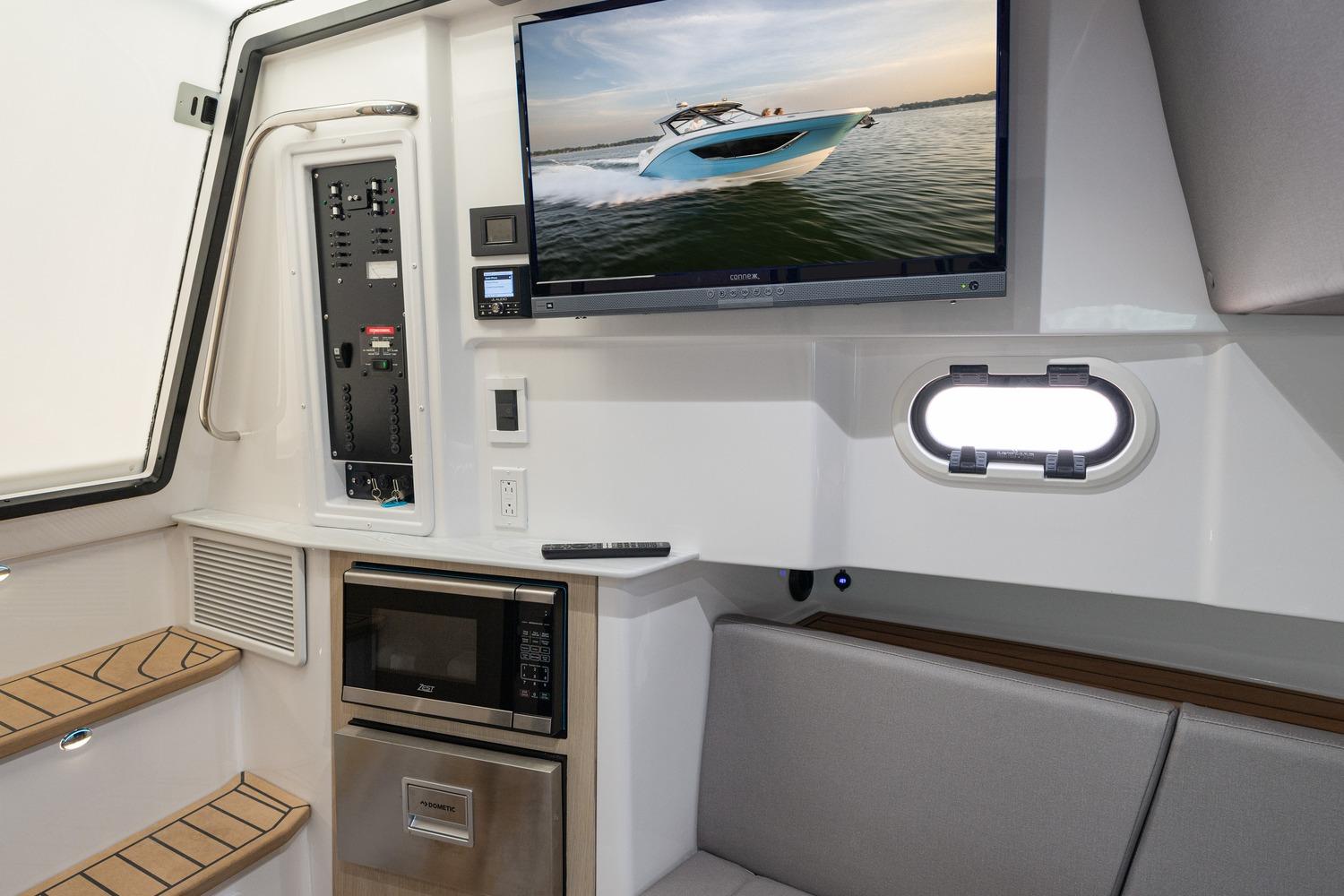 Interior of 2026 Hurricane SunDeck 3200 OB with TV, microwave, and seating area.