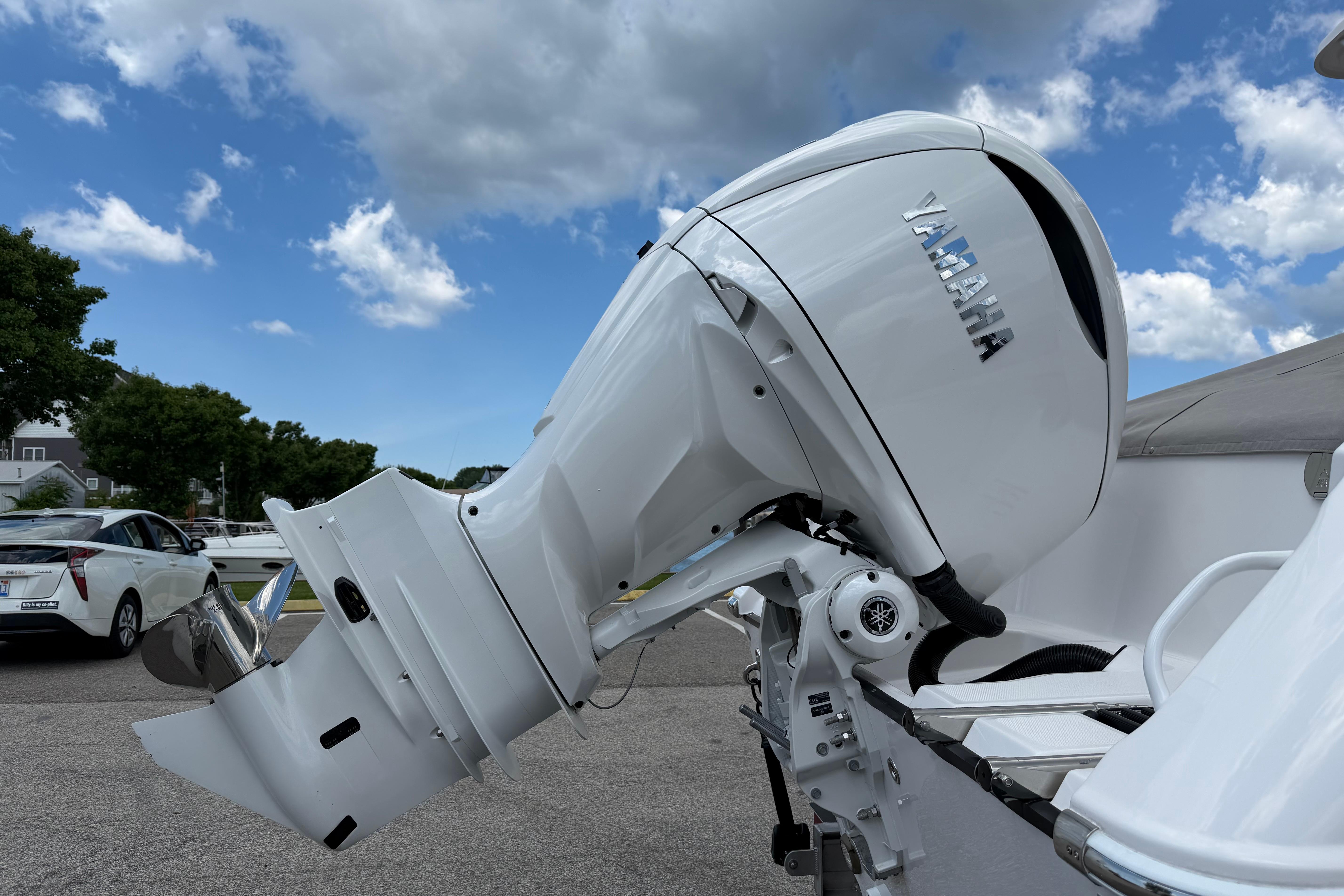 2026 Edgewater 248CX Crossover boat with Yamaha outboard motor under a cloudy sky.