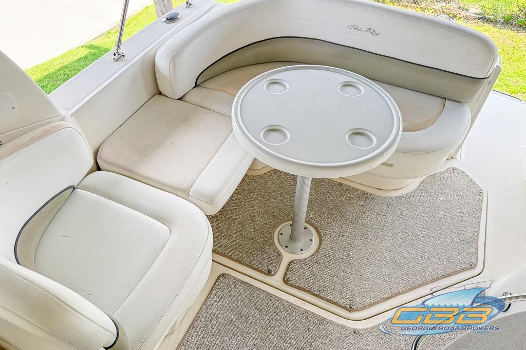 2006 Sea Ray Sundancer 260 interior with cushioned seating and round table.