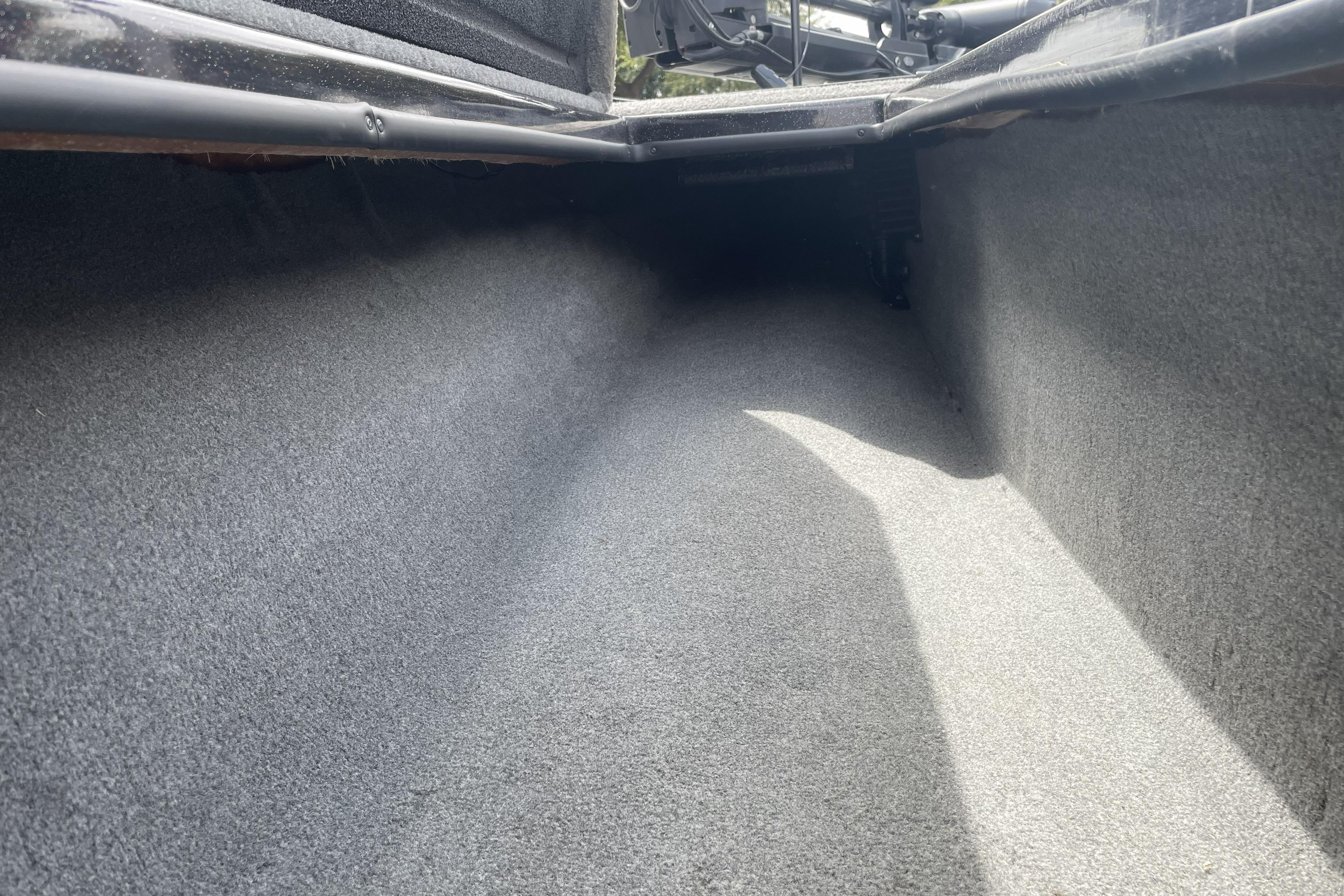 Carpeted storage compartment inside a 2013 Nitro Z-8 boat, showcasing spacious interior.