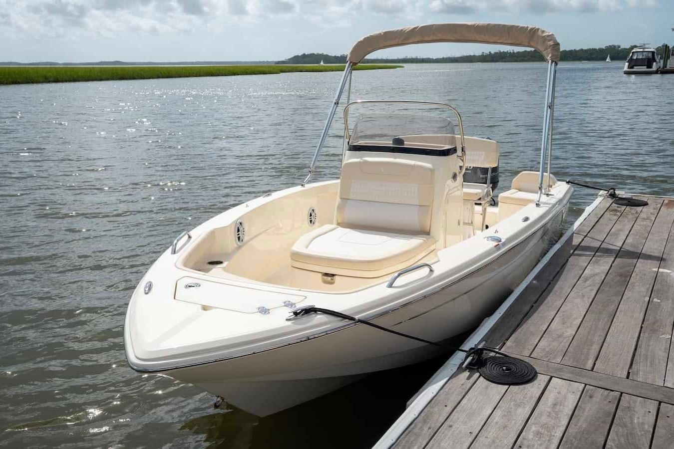 2026 Scout 188 Sportfish boat docked on a sunny day by the water.