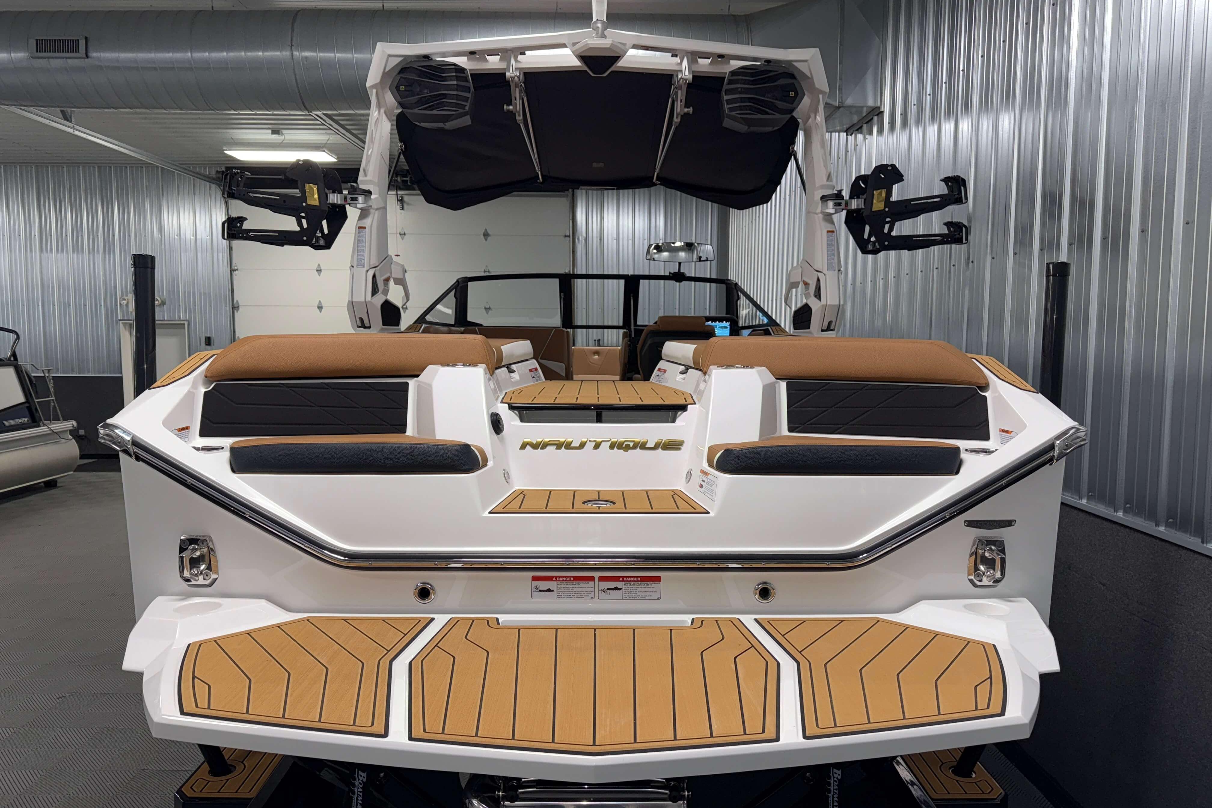 2026 Nautique Super Air Nautique S23 boat in showroom, rear view with teak deck.