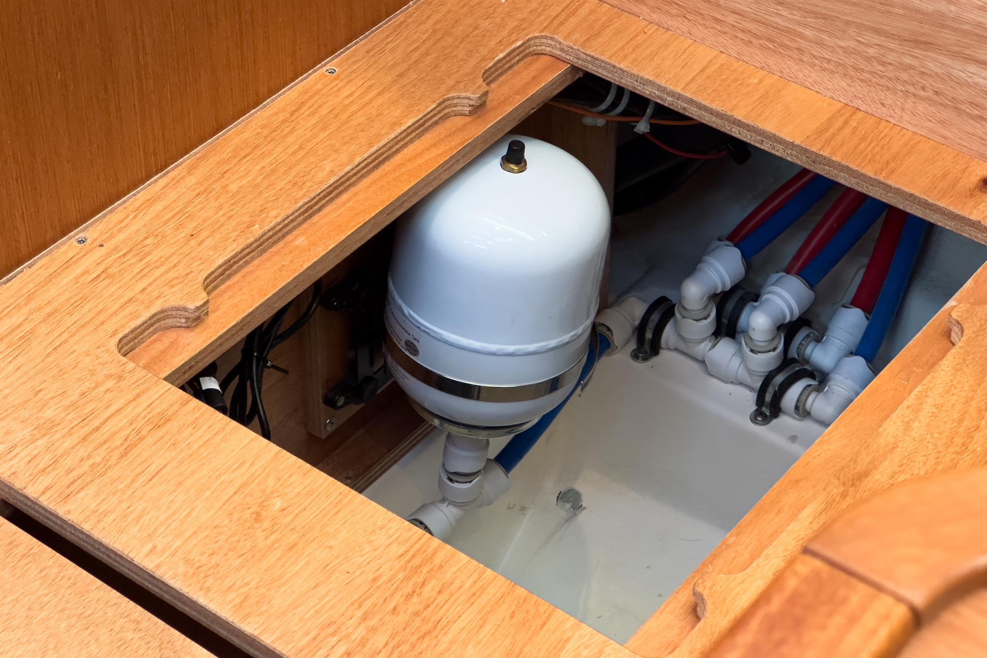 2023 Bavaria C50 yacht plumbing system with wooden paneling and water connections.