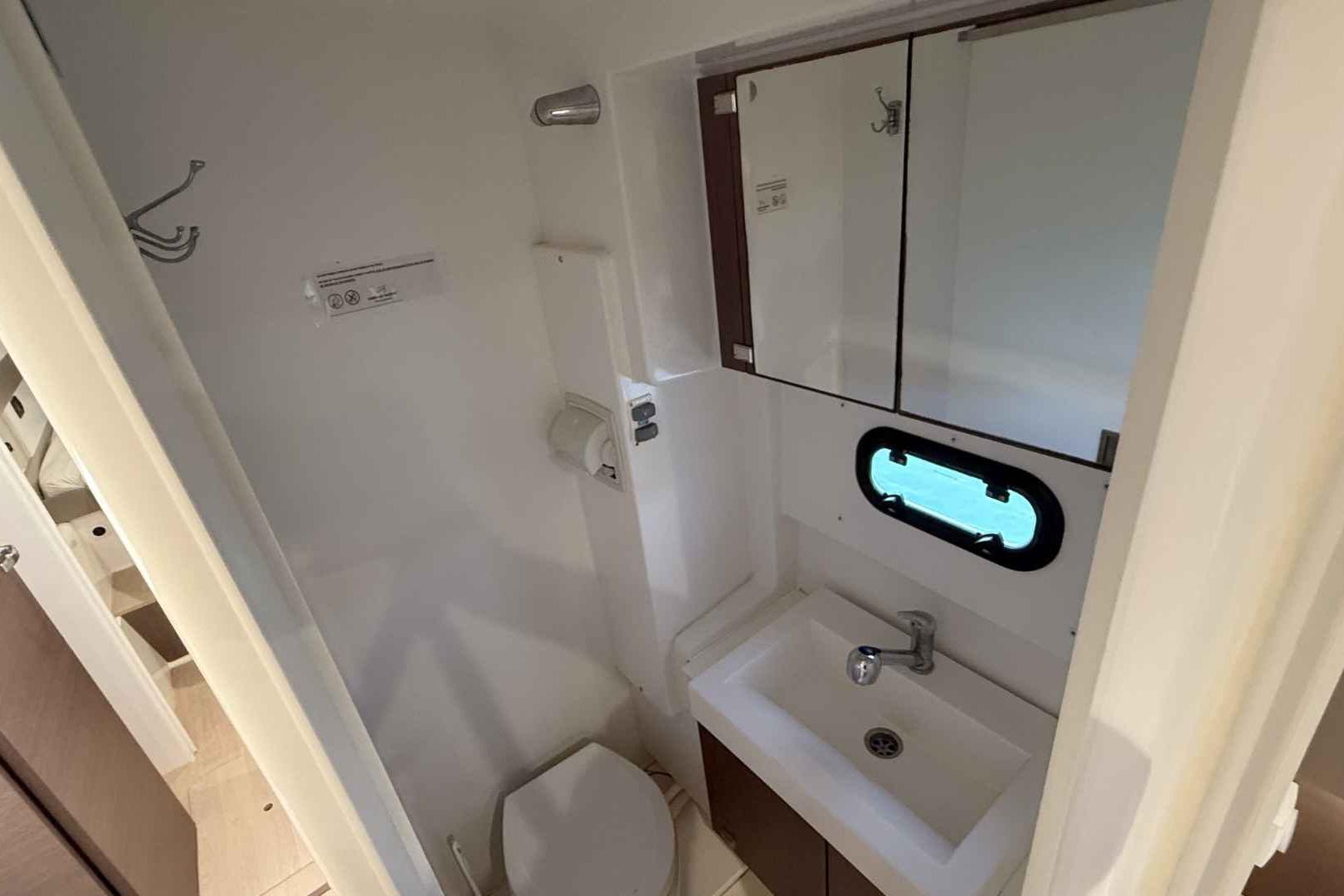Compact bathroom in 2020 Bali 4.3 model, featuring sink, mirror, and porthole window.