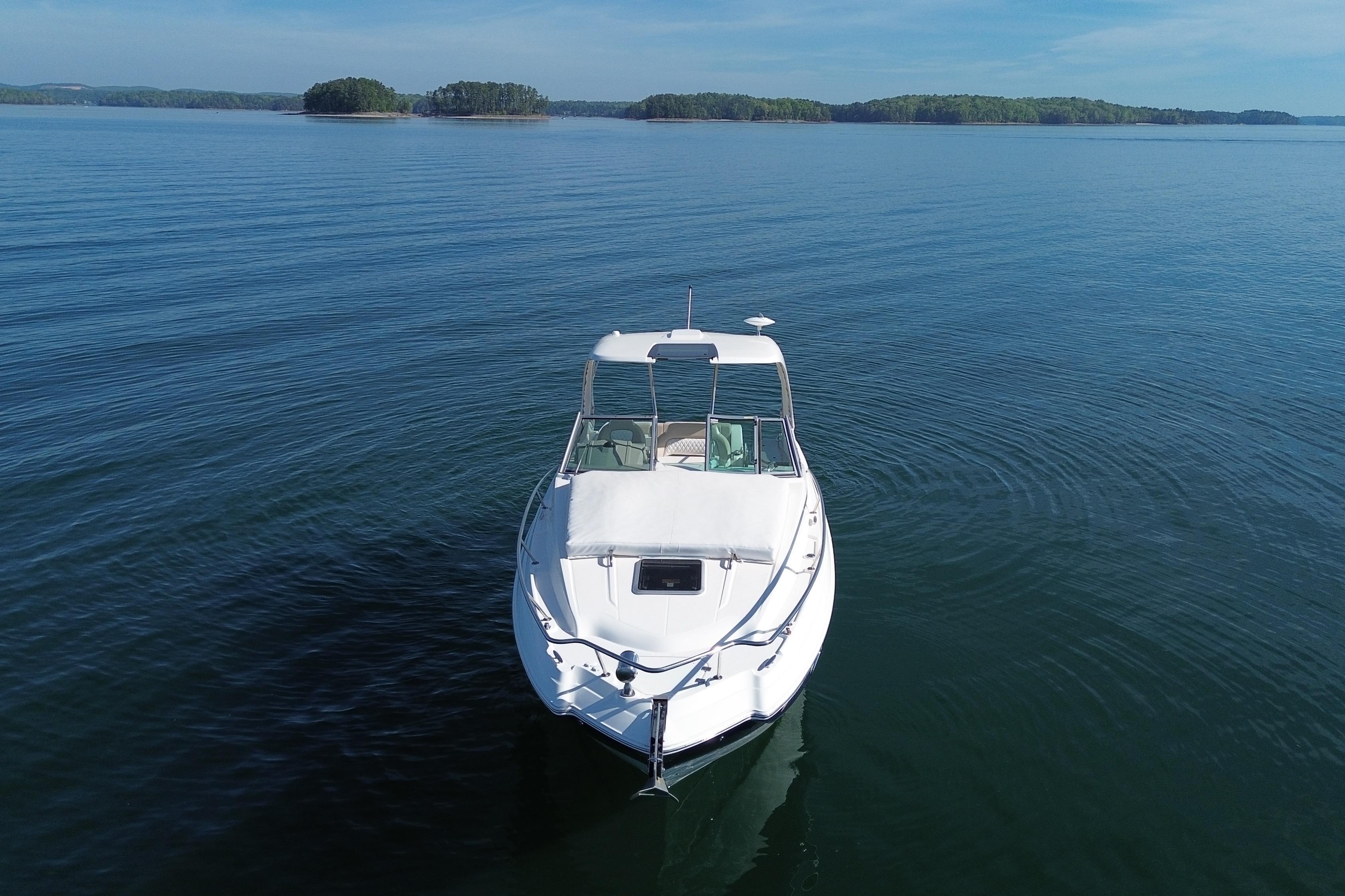 2014 Chaparral 310 Signature boat on calm lake with distant islands.