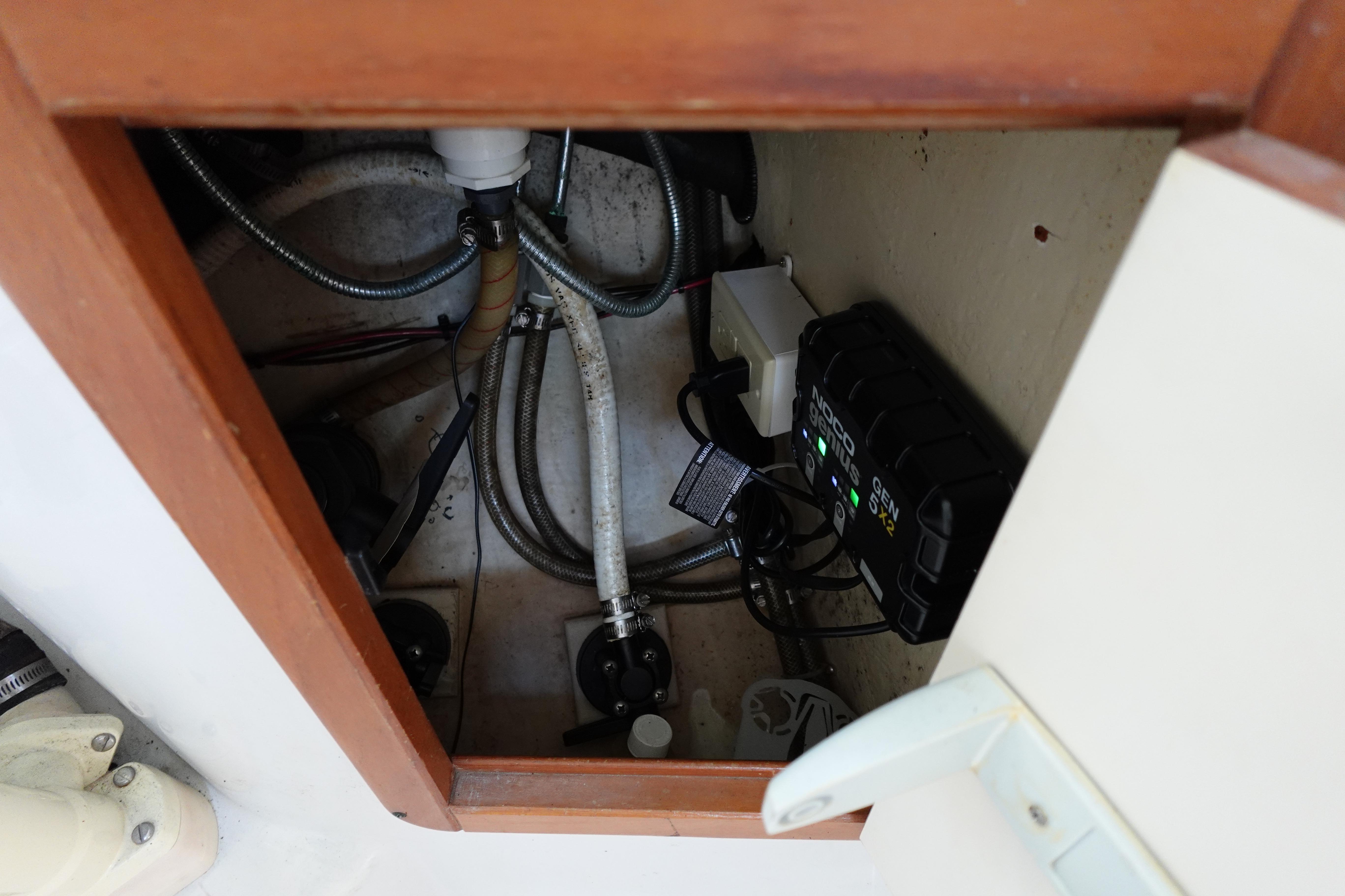 Electrical and plumbing components inside a 1997 Catalina 28 boat compartment.