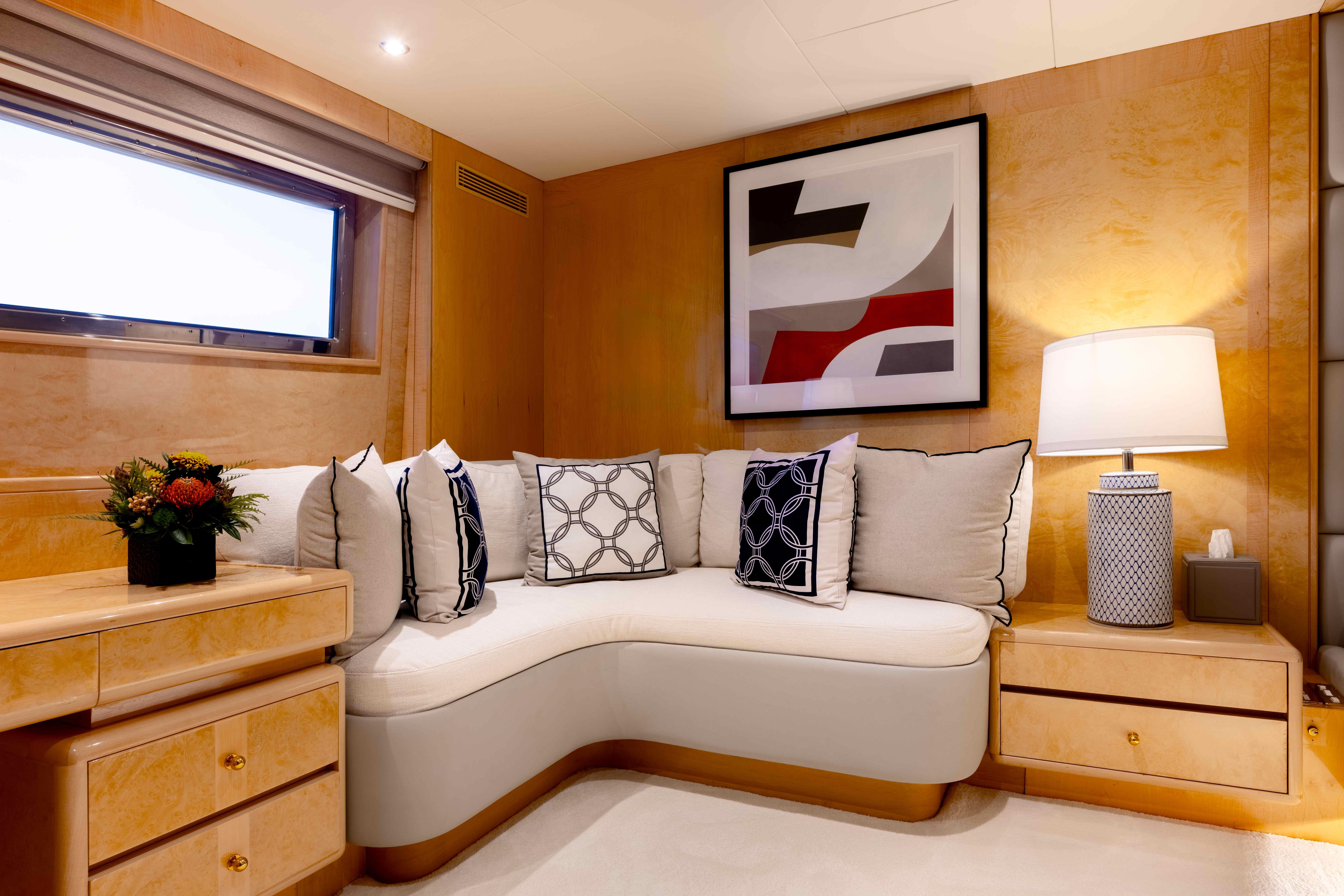 Luxurious yacht interior with modern decor, featuring a cozy sofa and elegant artwork.