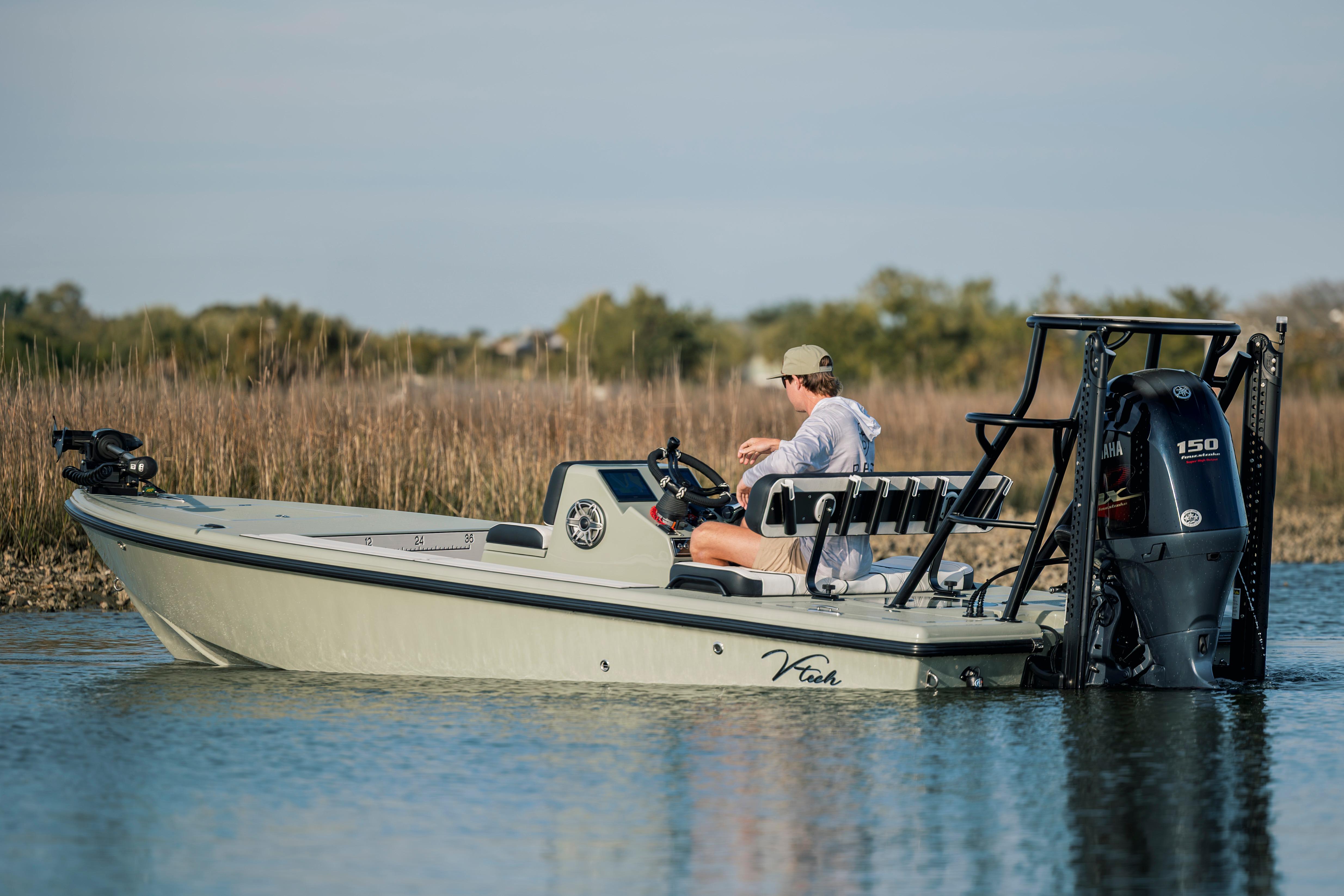 2025 Vtech 18 boat on water, person steering, Yamaha motor, natural background.