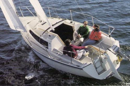 1989 O'Day 272 sailboat with three people sailing on open water.