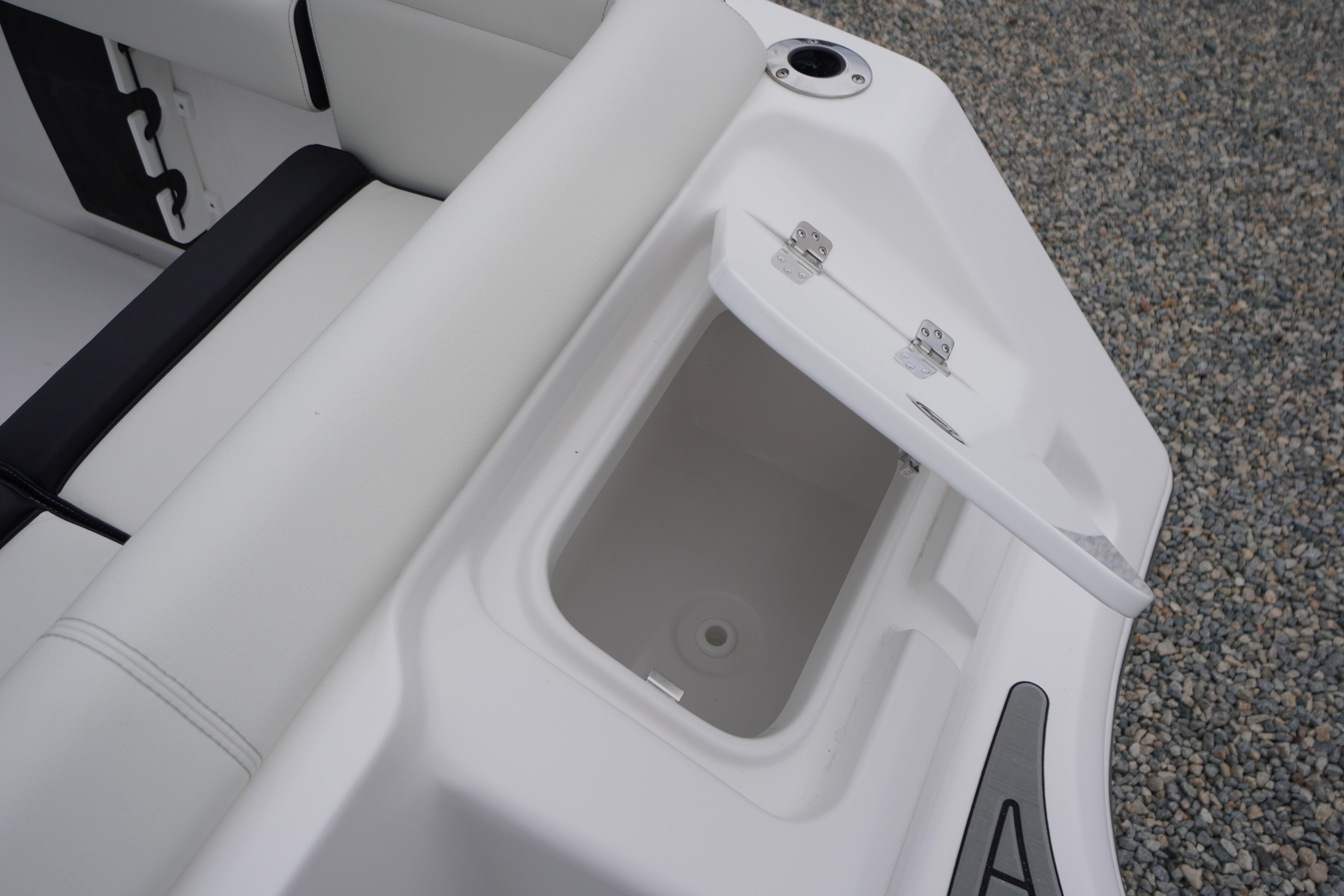 Open storage compartment on 2026 Tidewater 232 SS boat, featuring white cushioned seating.