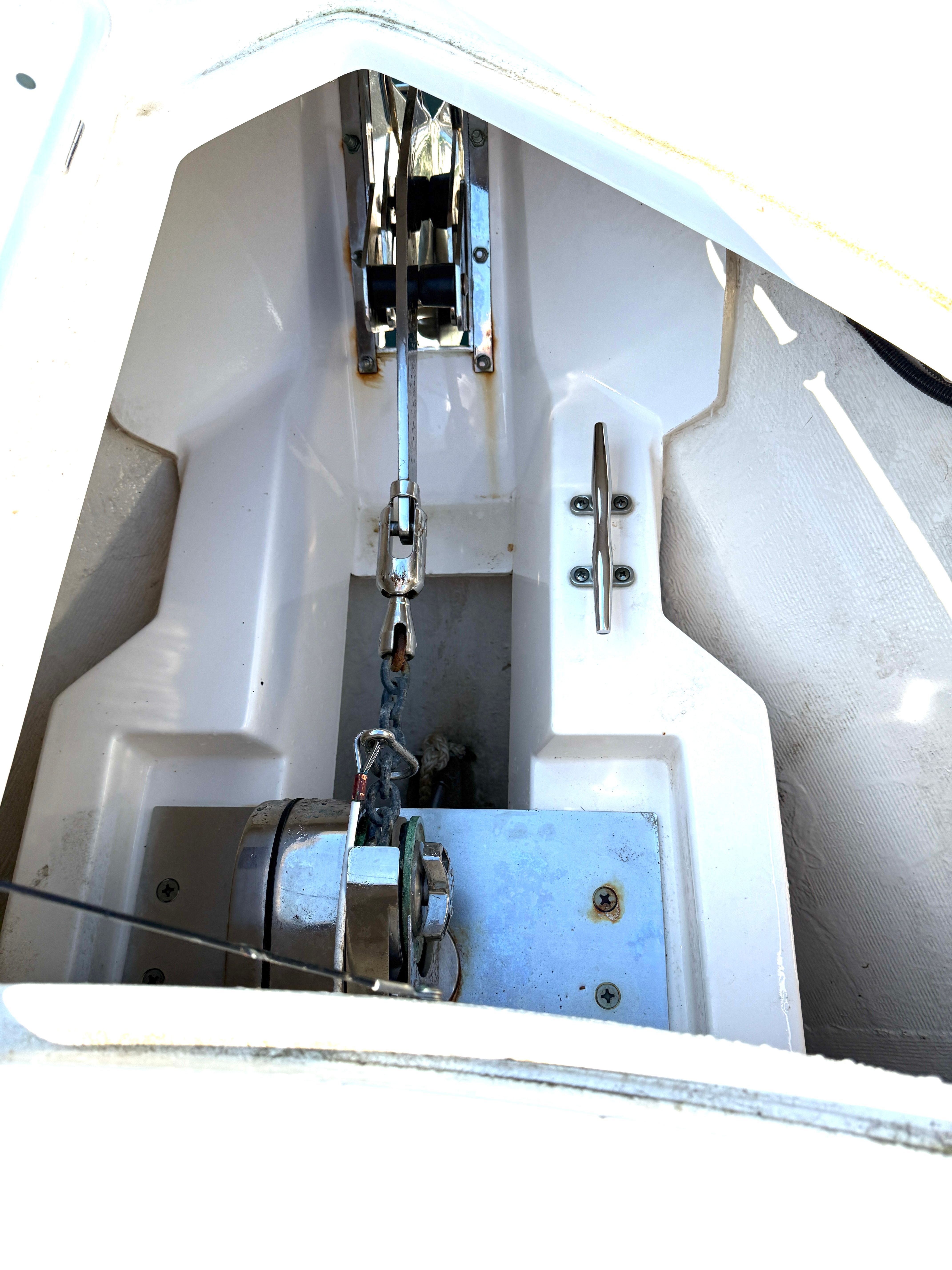 Anchor locker of a boat with windlass and chain.