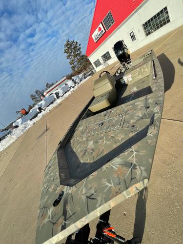2024 Tracker Grizzly 1648 SC boat in camouflage pattern outside dealership.