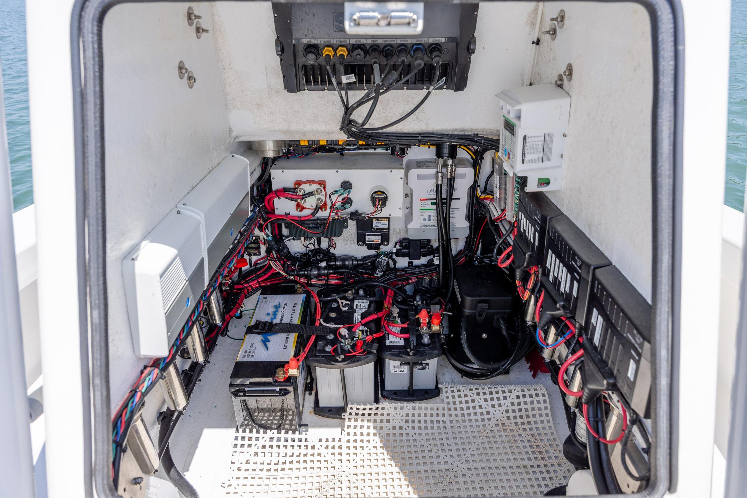 Electrical system inside a 2022 ZCB Freemason 26 boat, showcasing wiring and battery setup.
