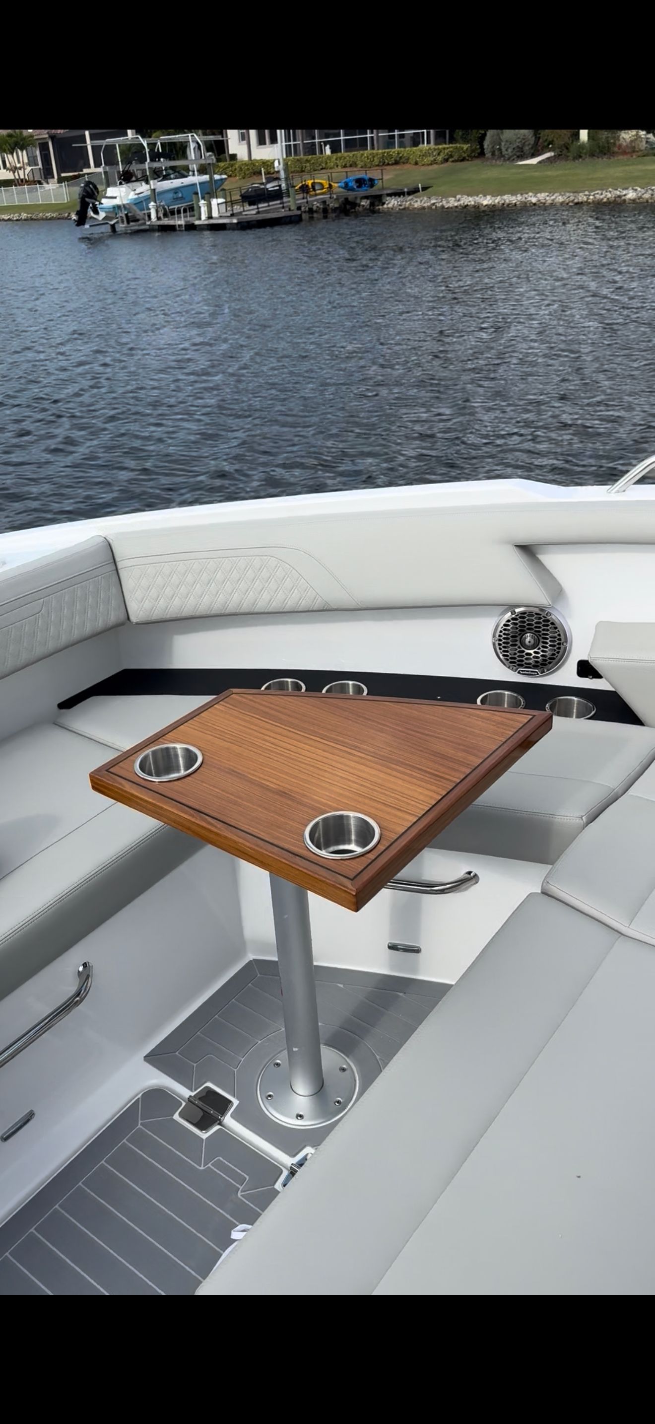 The image shows the cockpit of a 2025 New Cruiser Yachts 34GLS with a wooden table and white seating.