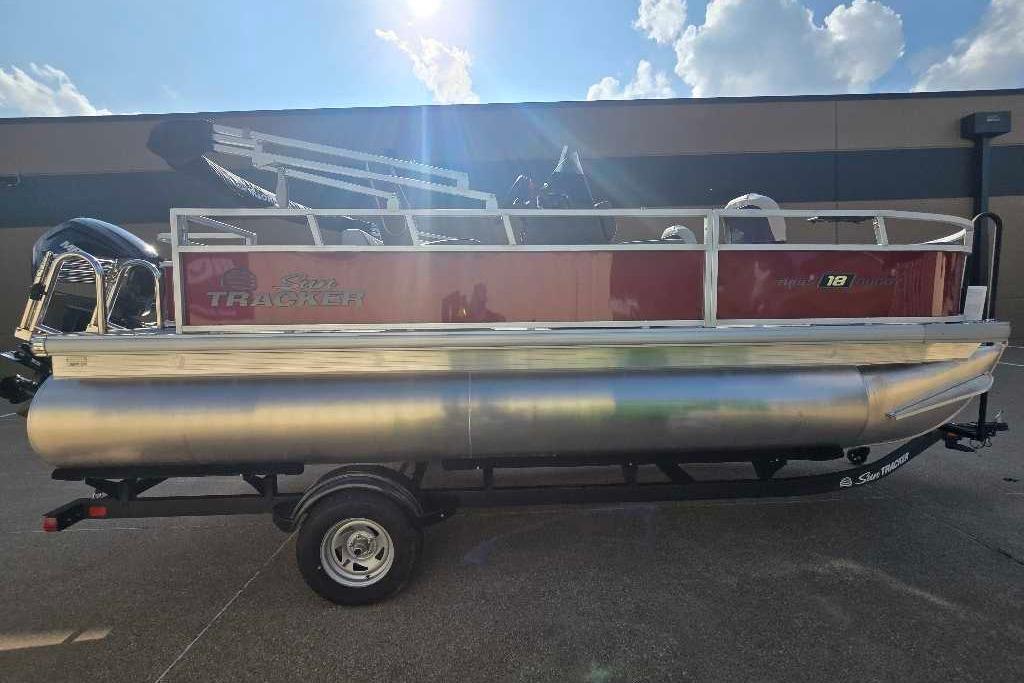 2026 Sun Tracker Bass Buggy 18 DLX pontoon boat on trailer, outdoors.