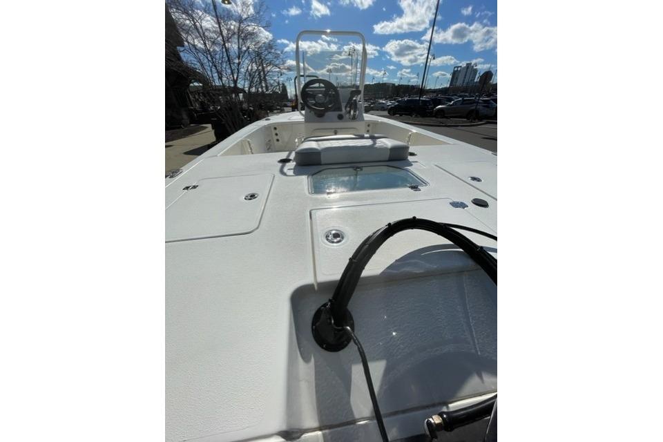 2026 Mako 18 Pro Skiff boat deck with steering console under a clear sky.