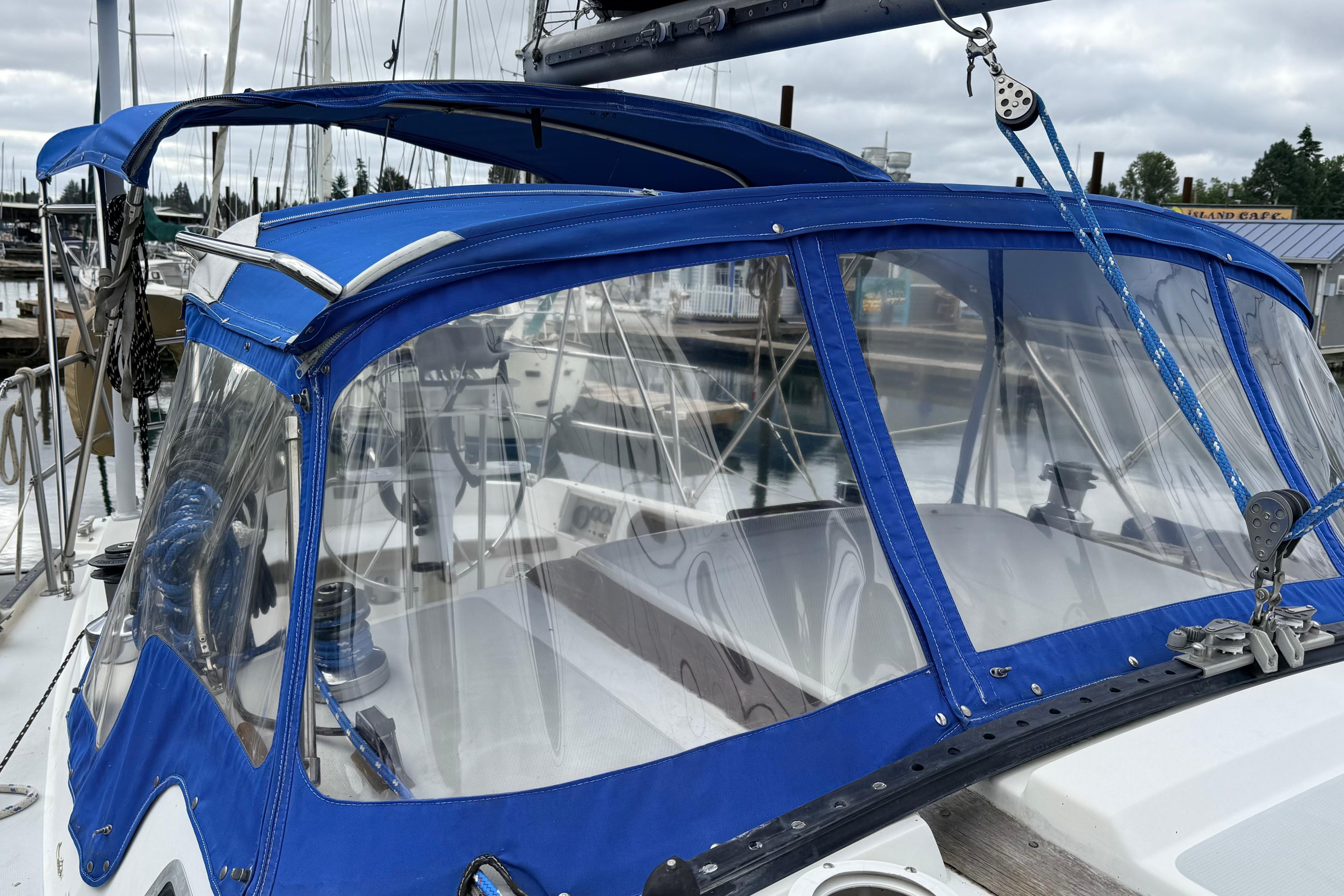 1985 Catalina 36 sailboat with blue canvas cover docked at marina.