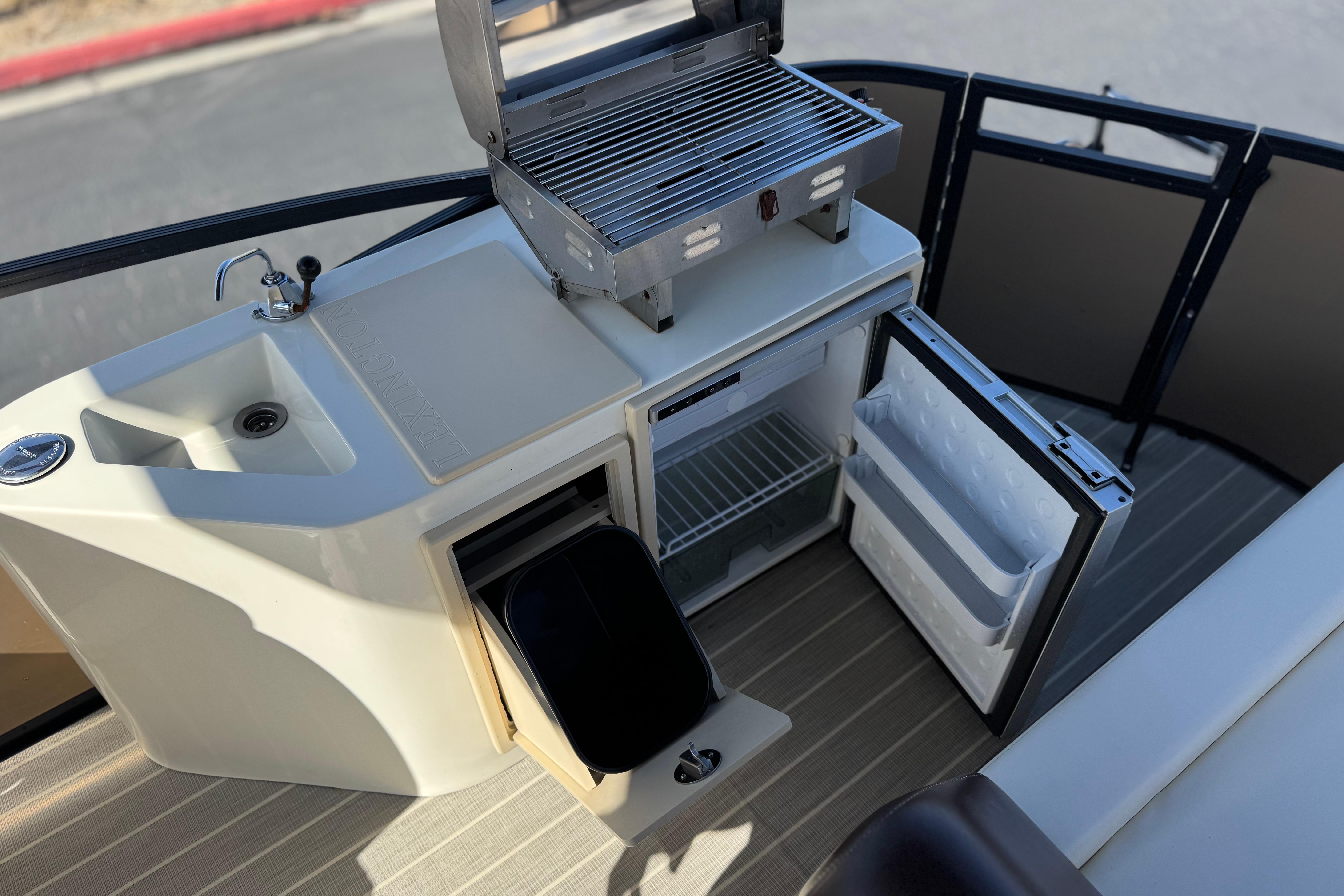 2023 Lexington 623 ST Xtreme boat kitchen with grill, sink, and mini fridge.