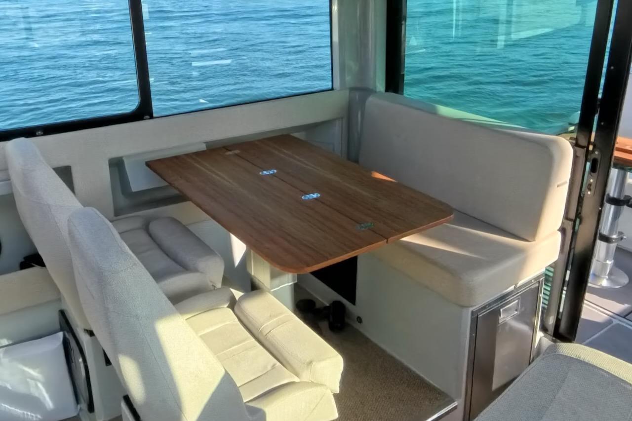 Interior of 2024 Saxdor 320 GTC boat with cozy seating and wooden table.