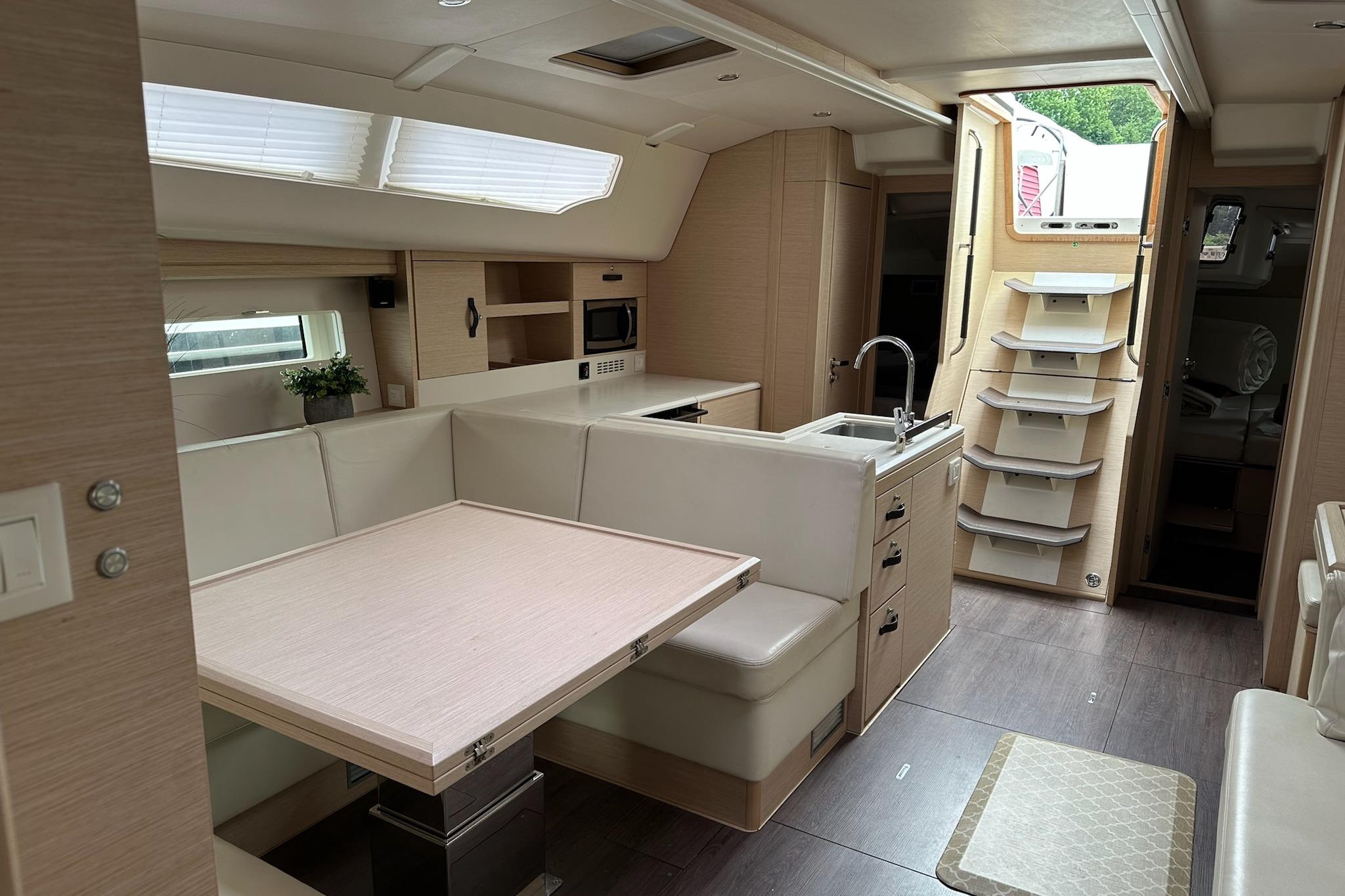 Luxurious interior of a 2018 Jeanneau 51 yacht, featuring modern kitchen and dining area.