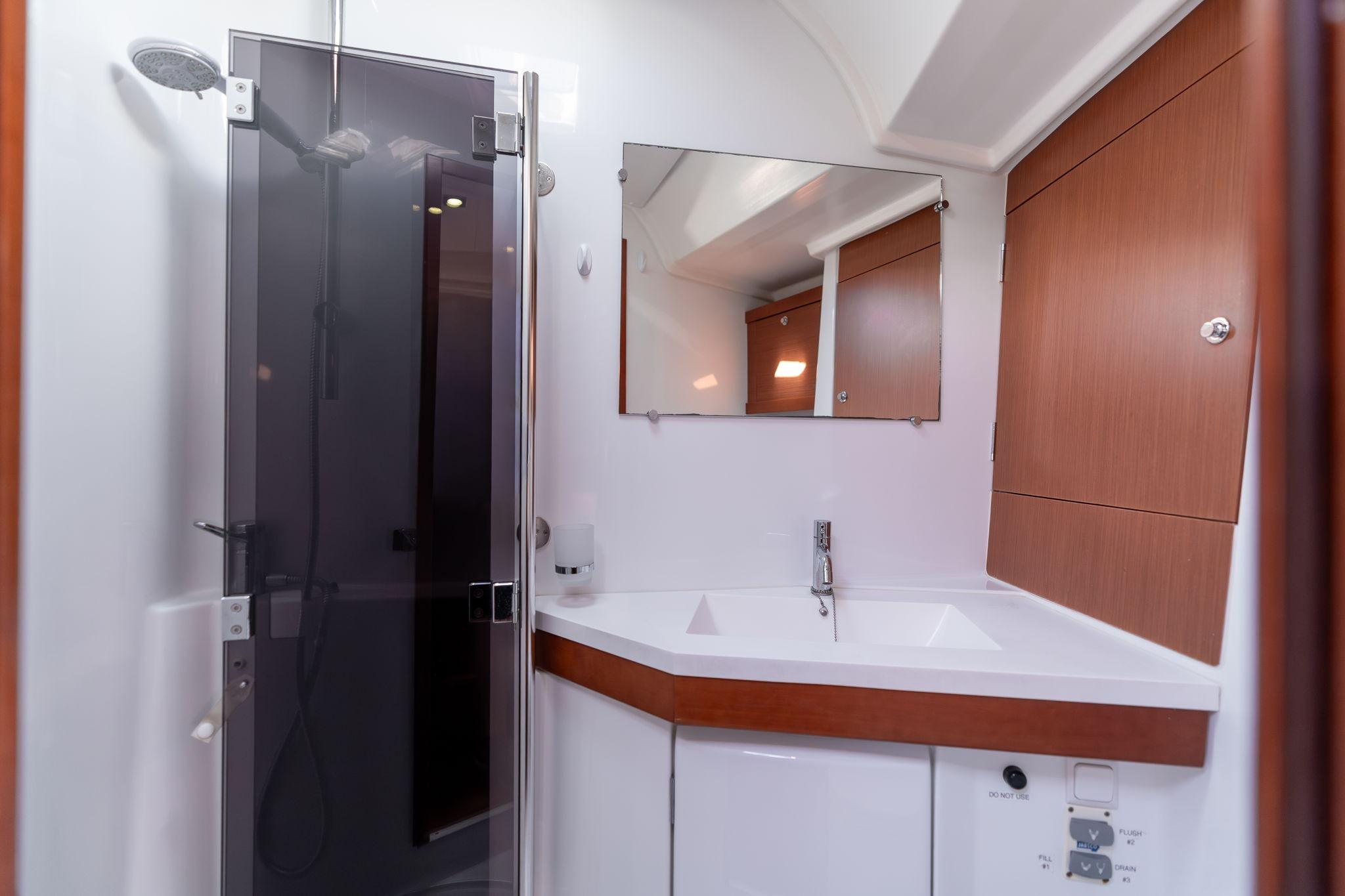 Modern bathroom in 2013 Beneteau Oceanis 50 yacht with shower and sink.