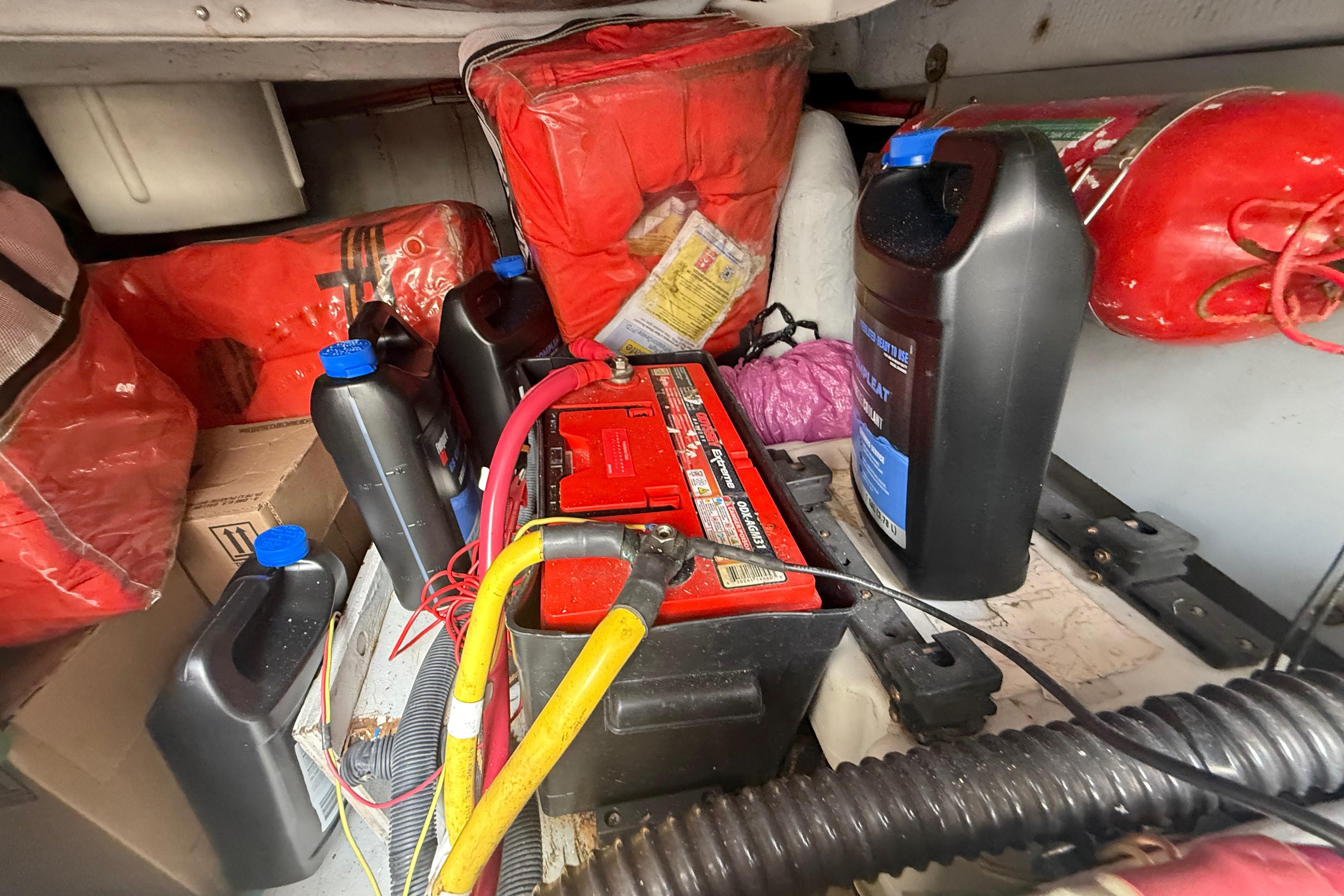 Engine room of 2007 Meridian 459 Motoryacht with battery, cables, and maintenance supplies.