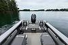 2023 Lund 1975 Tyee boat on calm lake, featuring spacious deck and modern outboard motor.