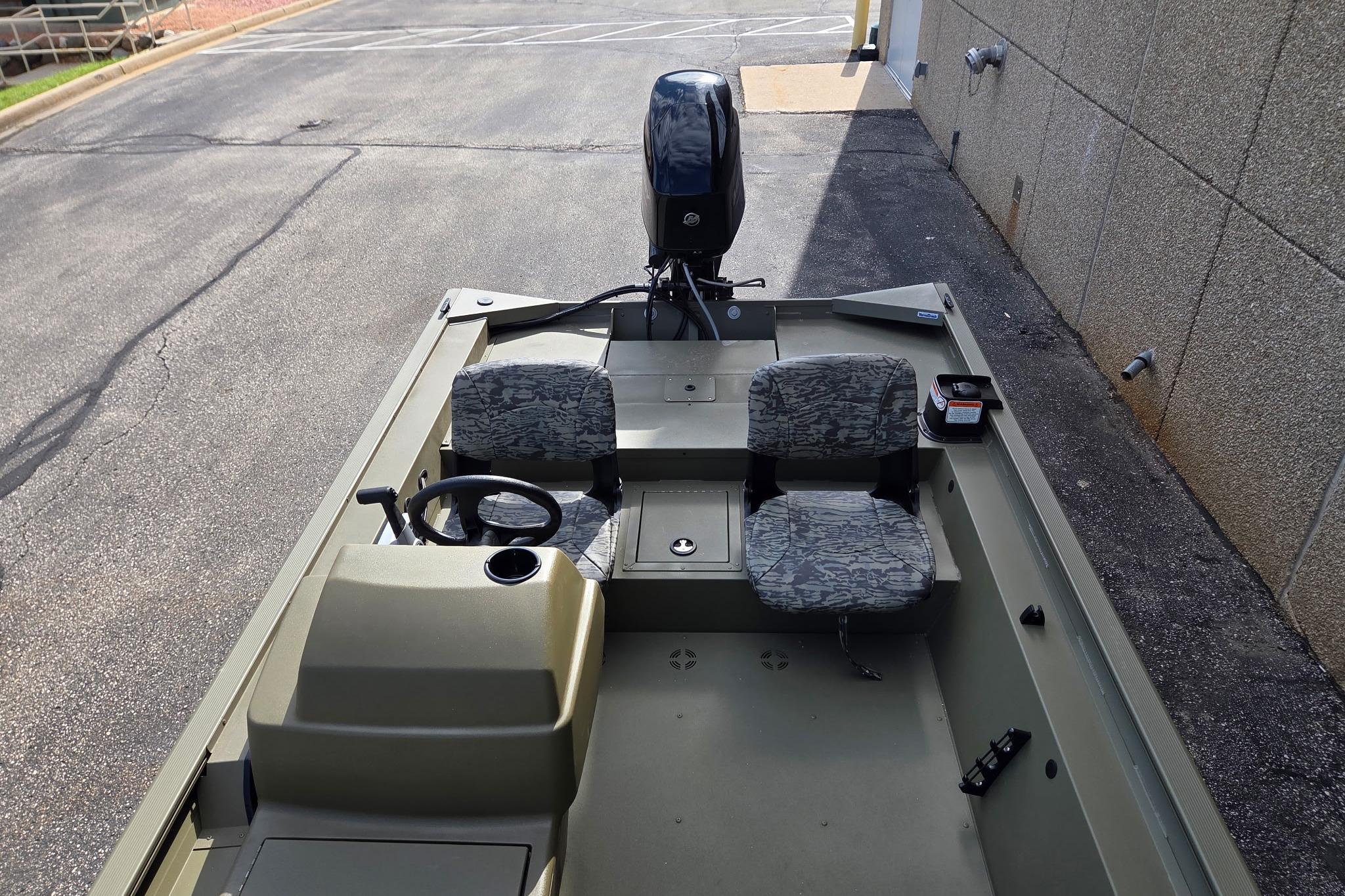 2026 Tracker Grizzly 1754 SC boat with dual seats and steering console, parked outdoors.