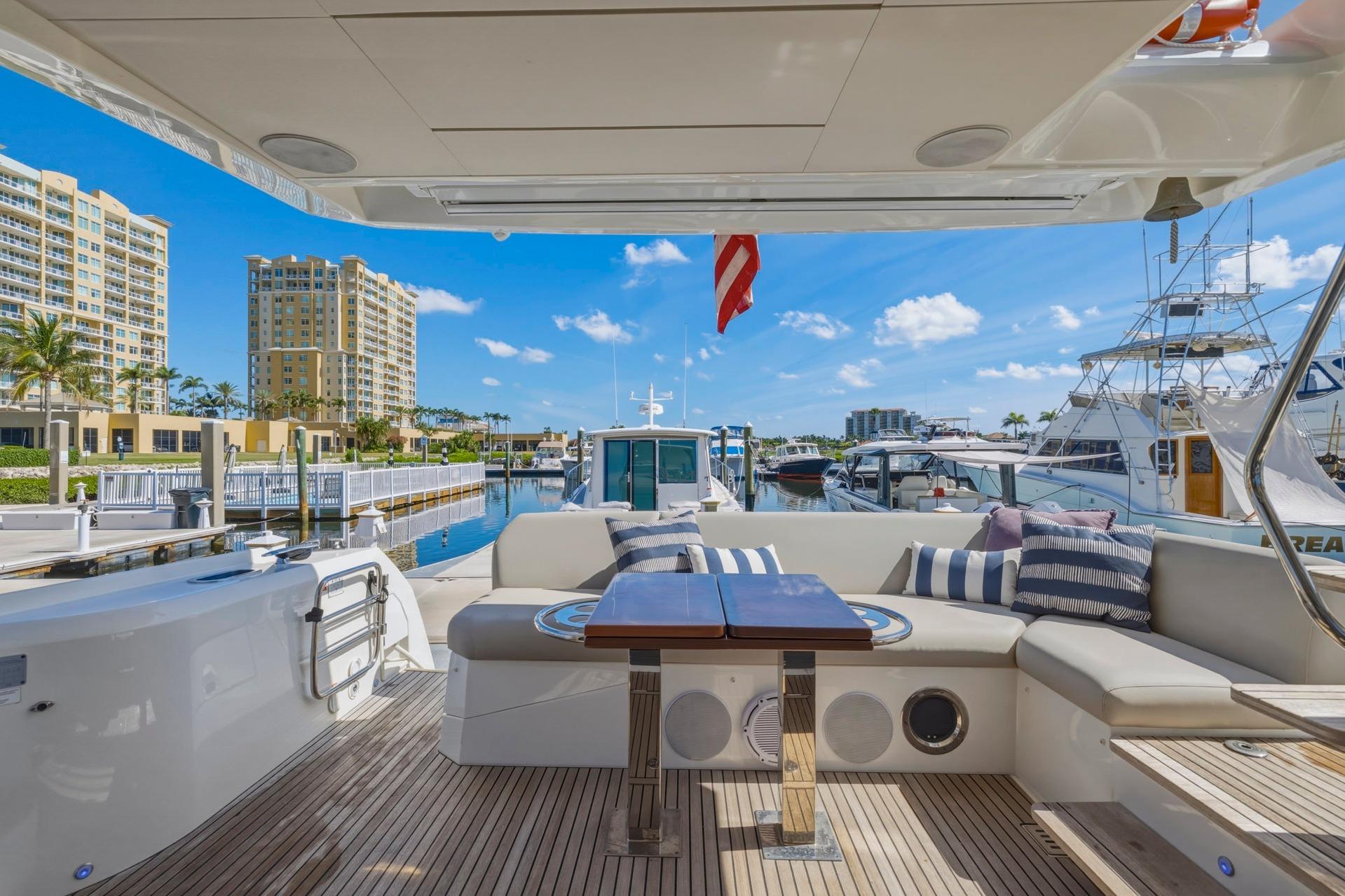 Luxurious 2022 Prestige 520 yacht interior with elegant seating, docked in a scenic marina.