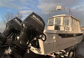 2026 C-Dory TOMCAT 255 boat with dual Suzuki outboard motors on a trailer.